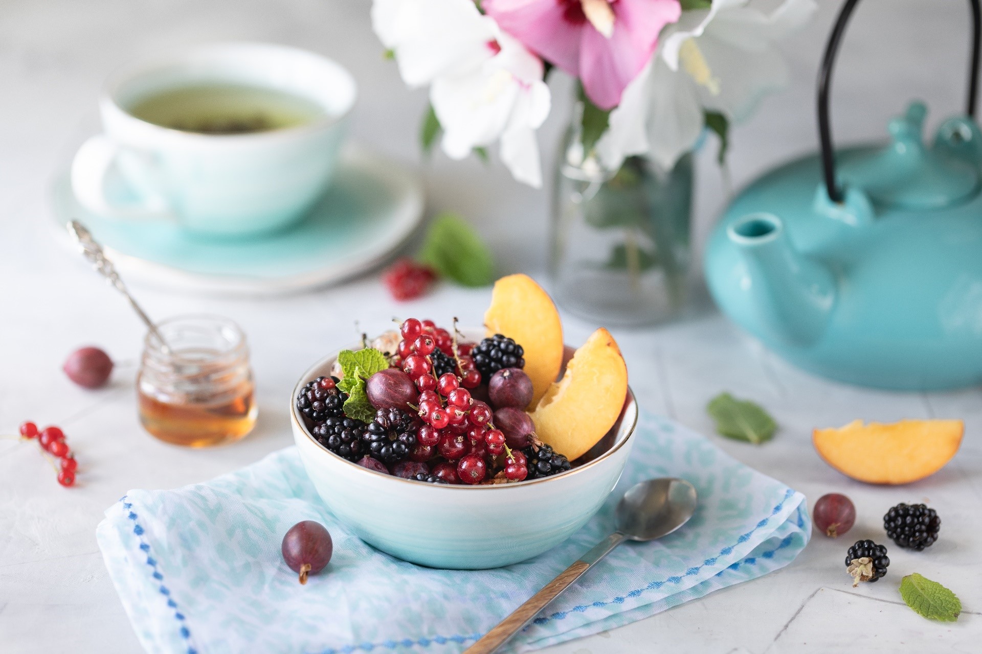 Bowl of berries with peach slices, tea, and teapot HD Wallpaper