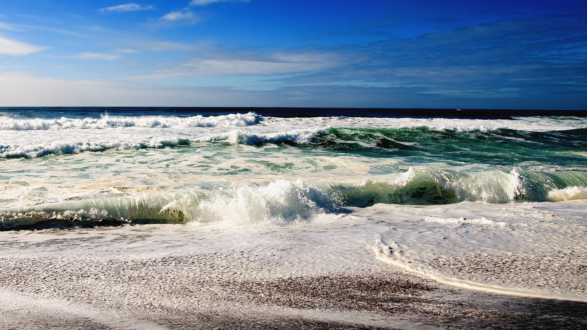 Ocean waves crashing on a sandy beach HD Wallpaper