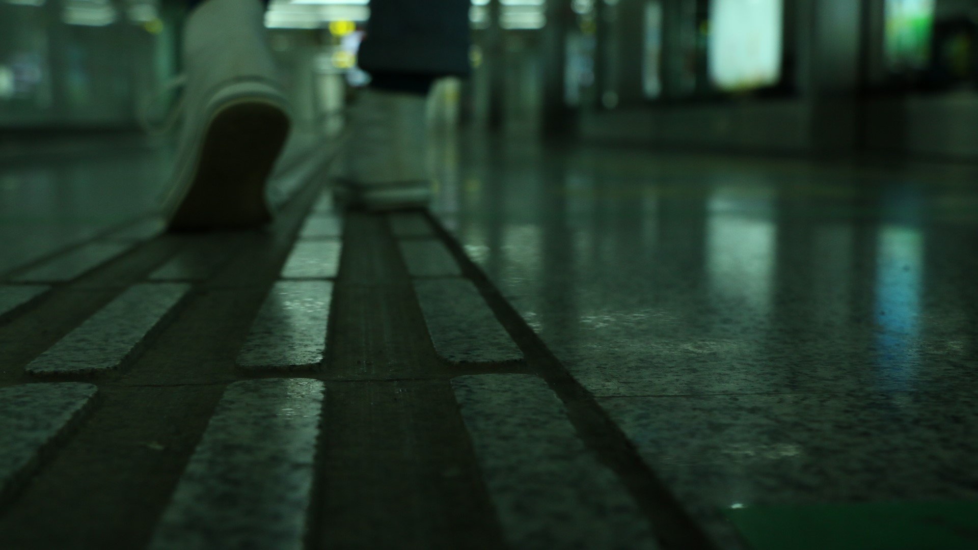 Person walking on tactile paving in a subway station HD Wallpaper