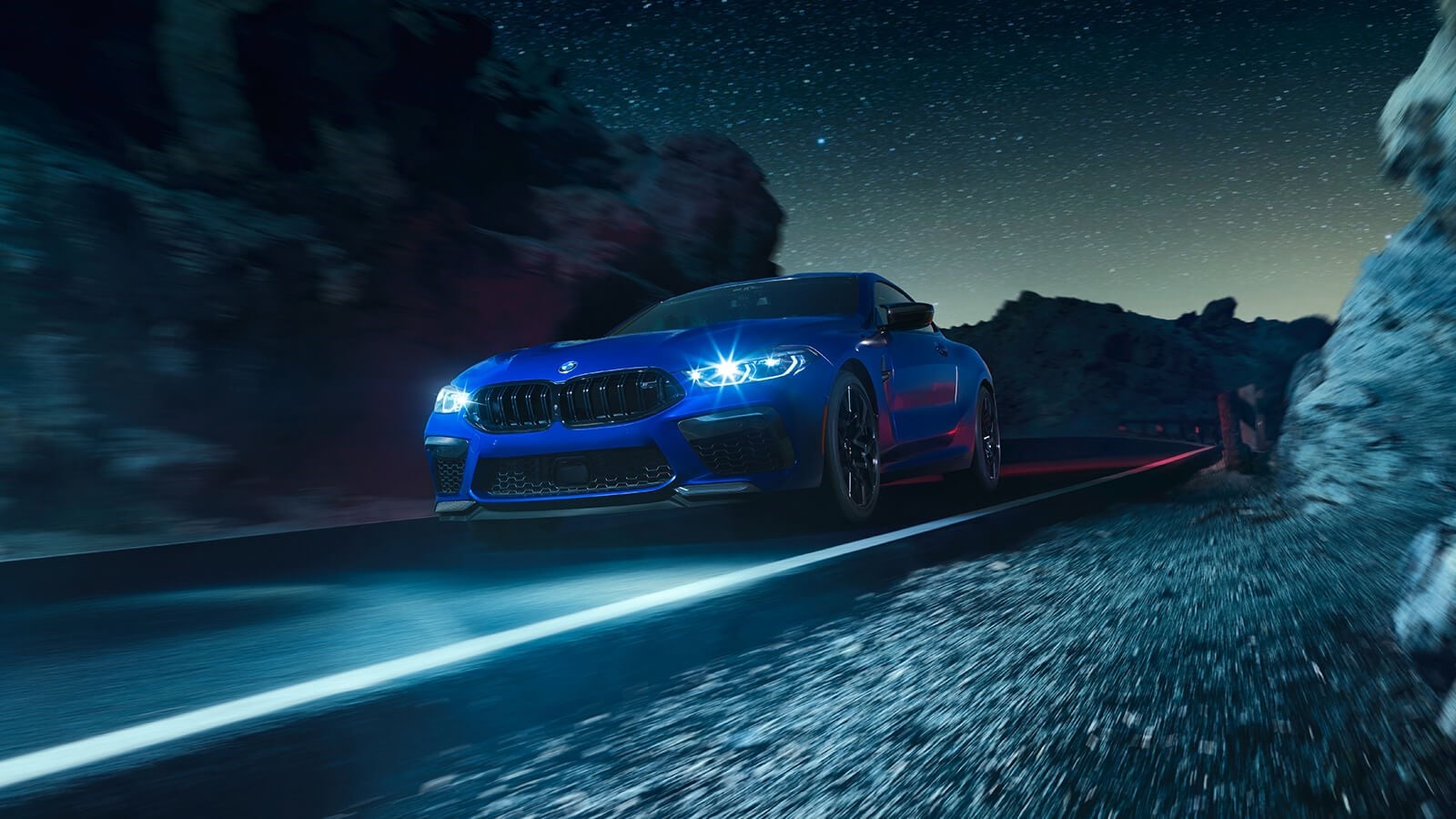 Blue BMW M8 Coupe driving on a mountain road at night HD Wallpaper