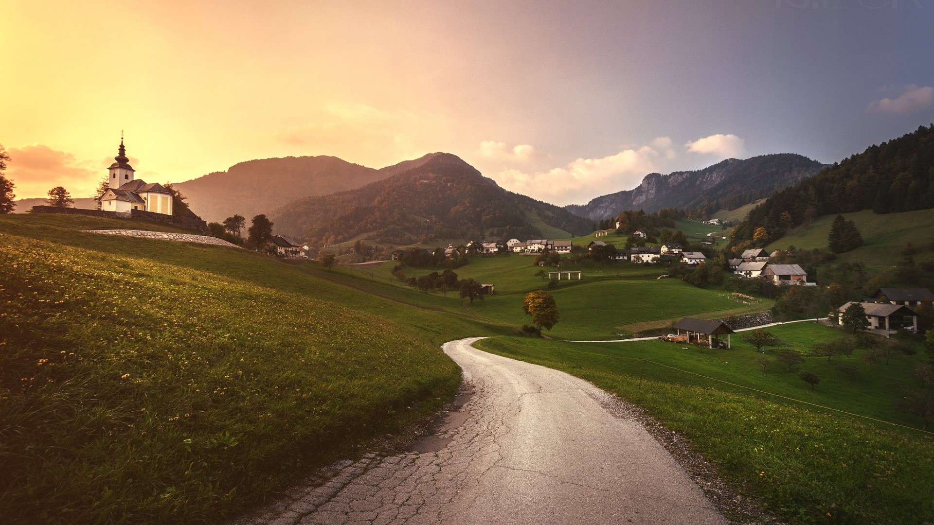 Village church on a hill with a winding road in Slovenia HD Wallpaper