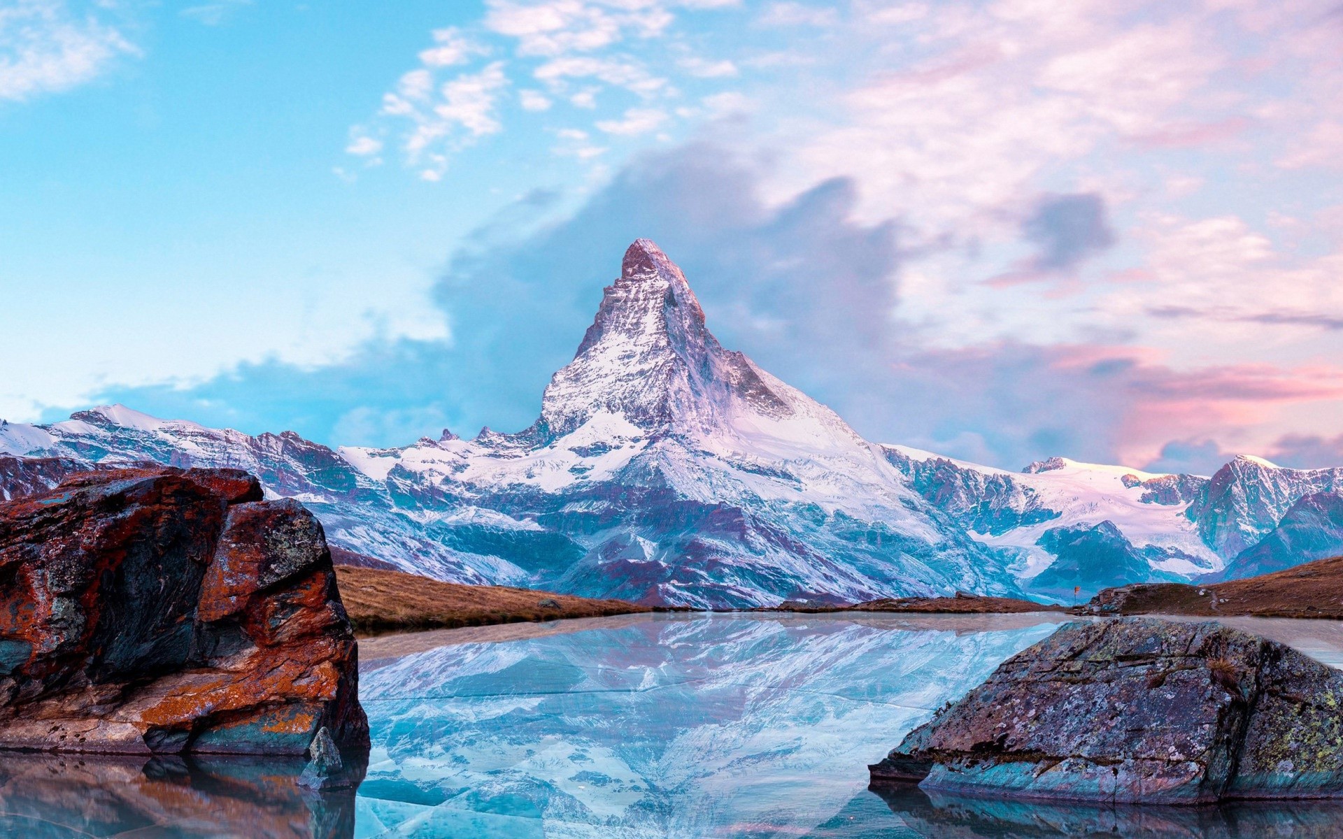 Matterhorn mountain reflected in a lake with rocks HD Wallpaper