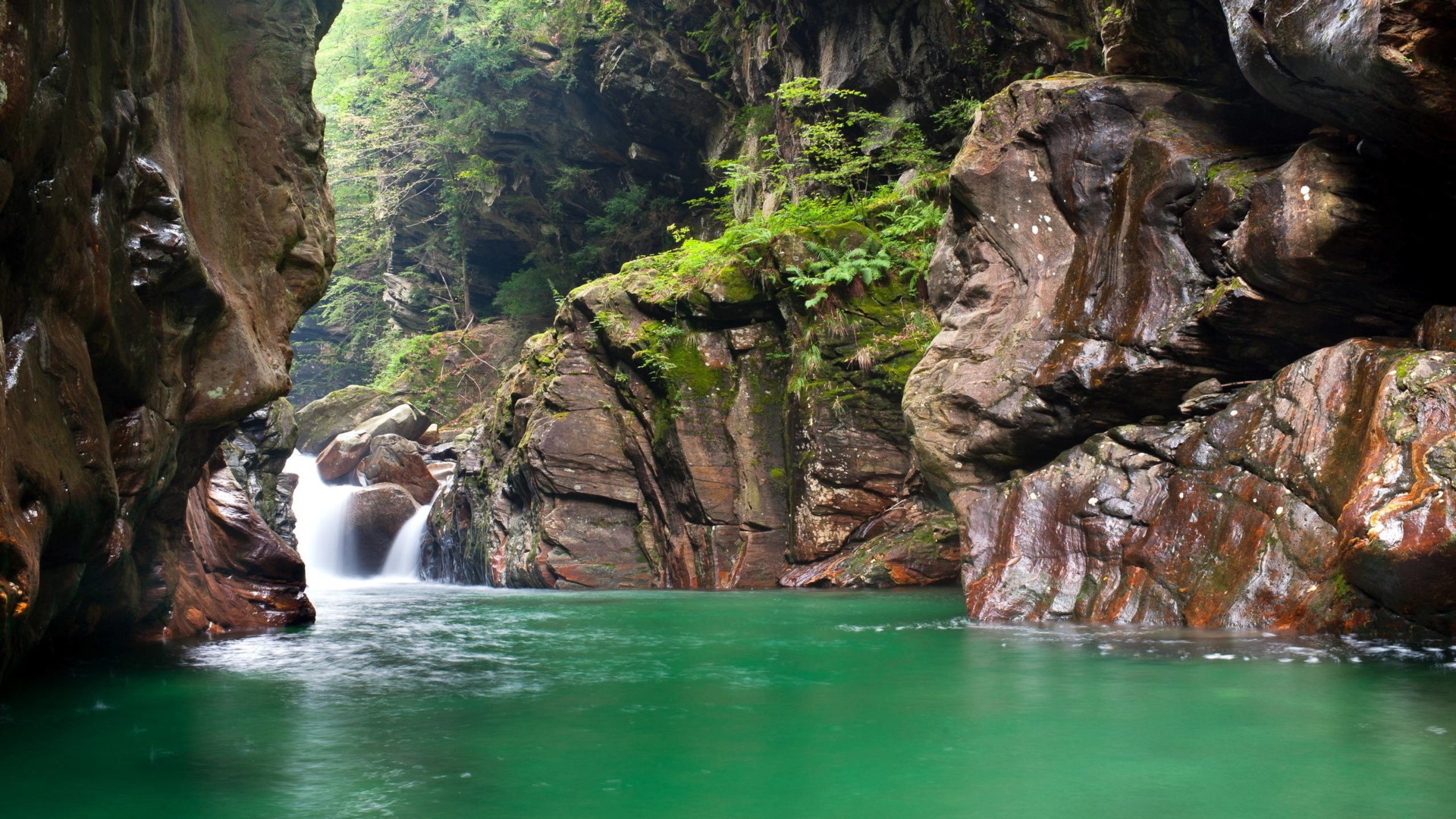 Waterfall in a rocky gorge with green water HD Wallpaper