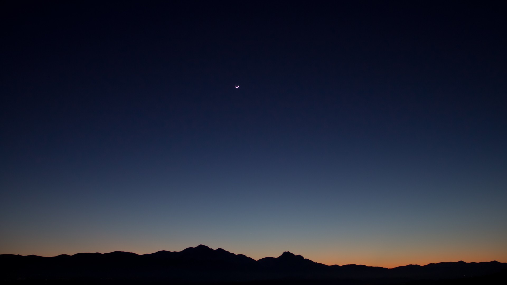 Crescent moon over silhouetted mountains at dusk HD Wallpaper
