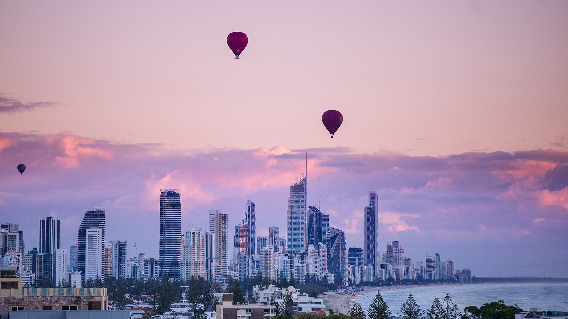 Hot air balloons over Gold Coast skyline at sunrise HD Wallpaper
