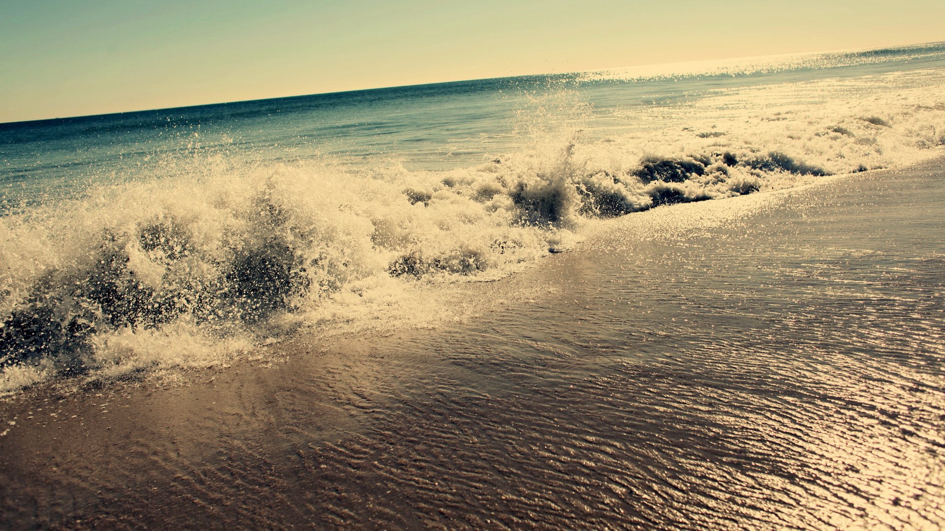 Ocean wave crashing on a sandy beach HD Wallpaper