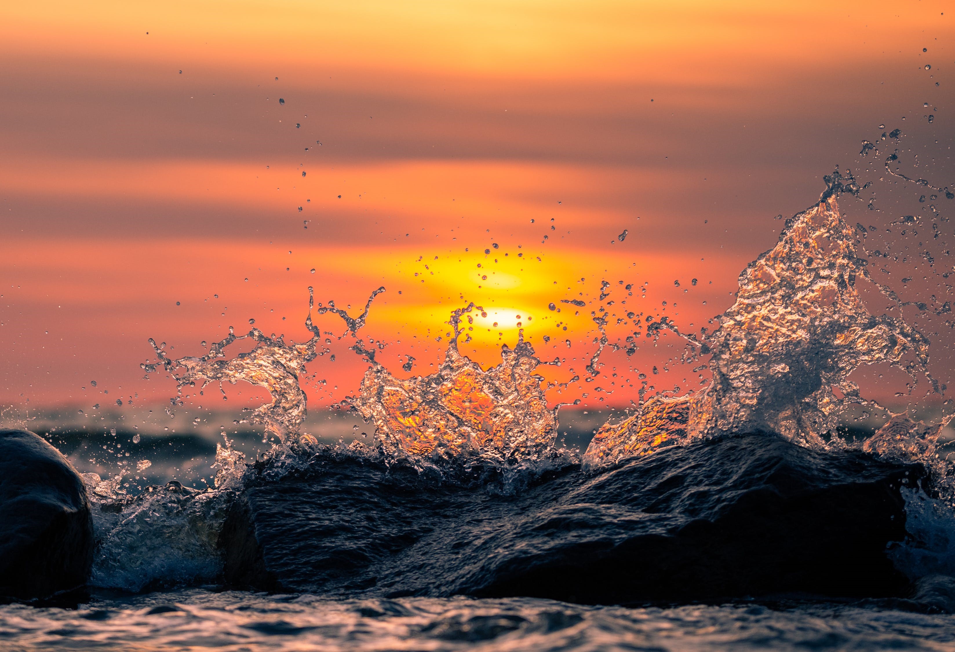 Waves crashing on rocks at sunset HD Wallpaper