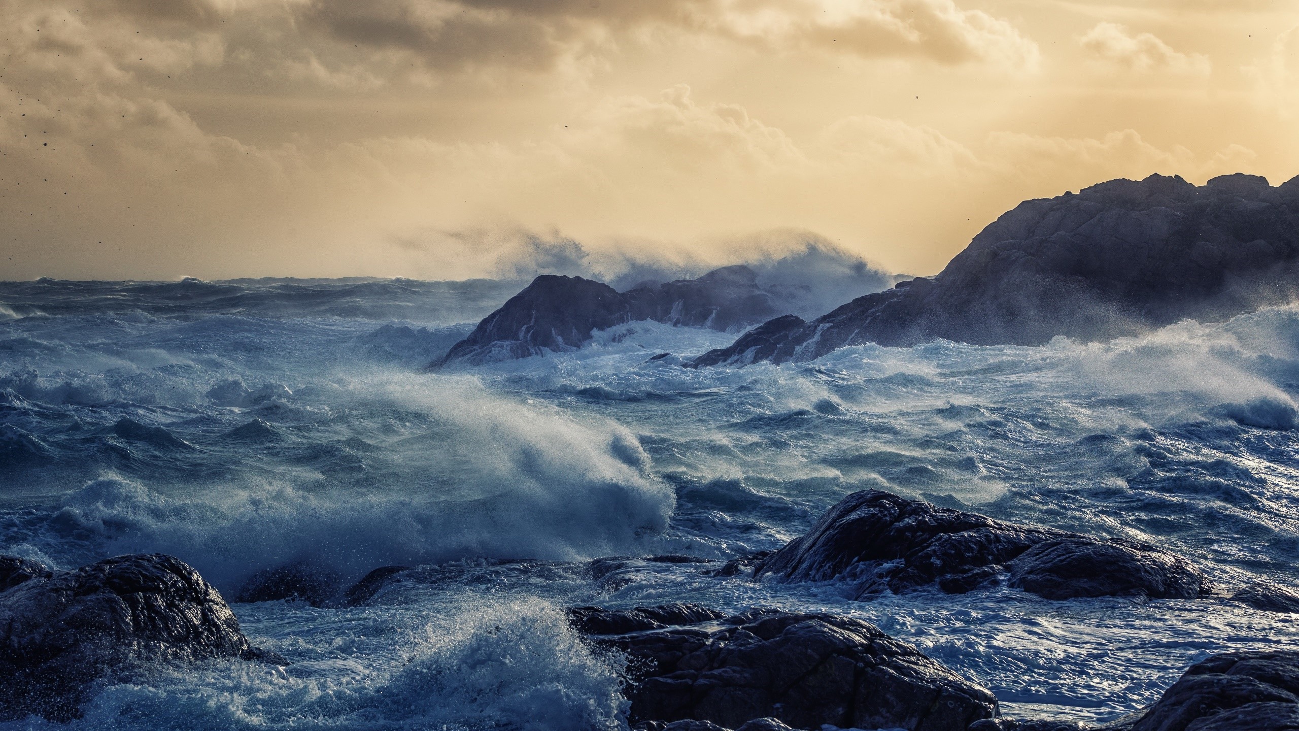Stormy sea crashing against rocky coast under cloudy sky HD Wallpaper
