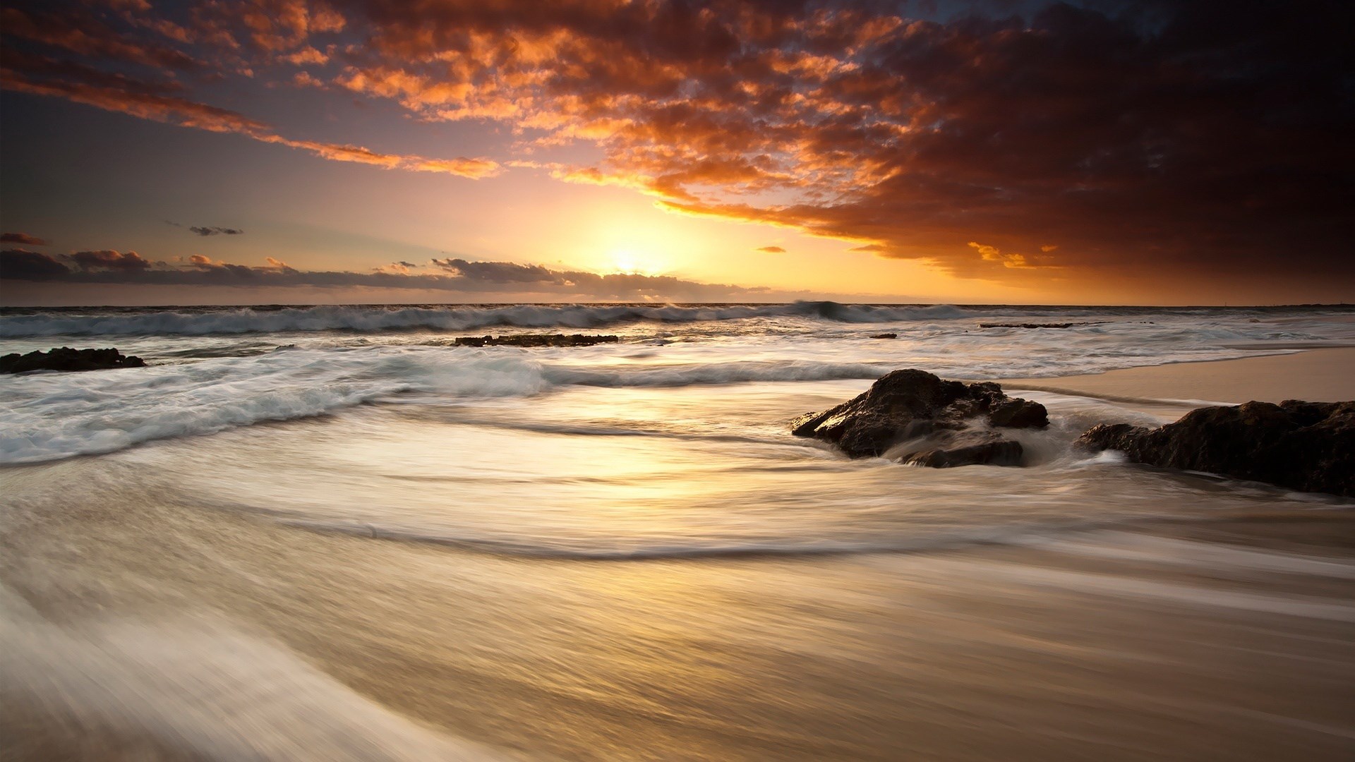 Sunset over the ocean with waves and rocks HD Wallpaper