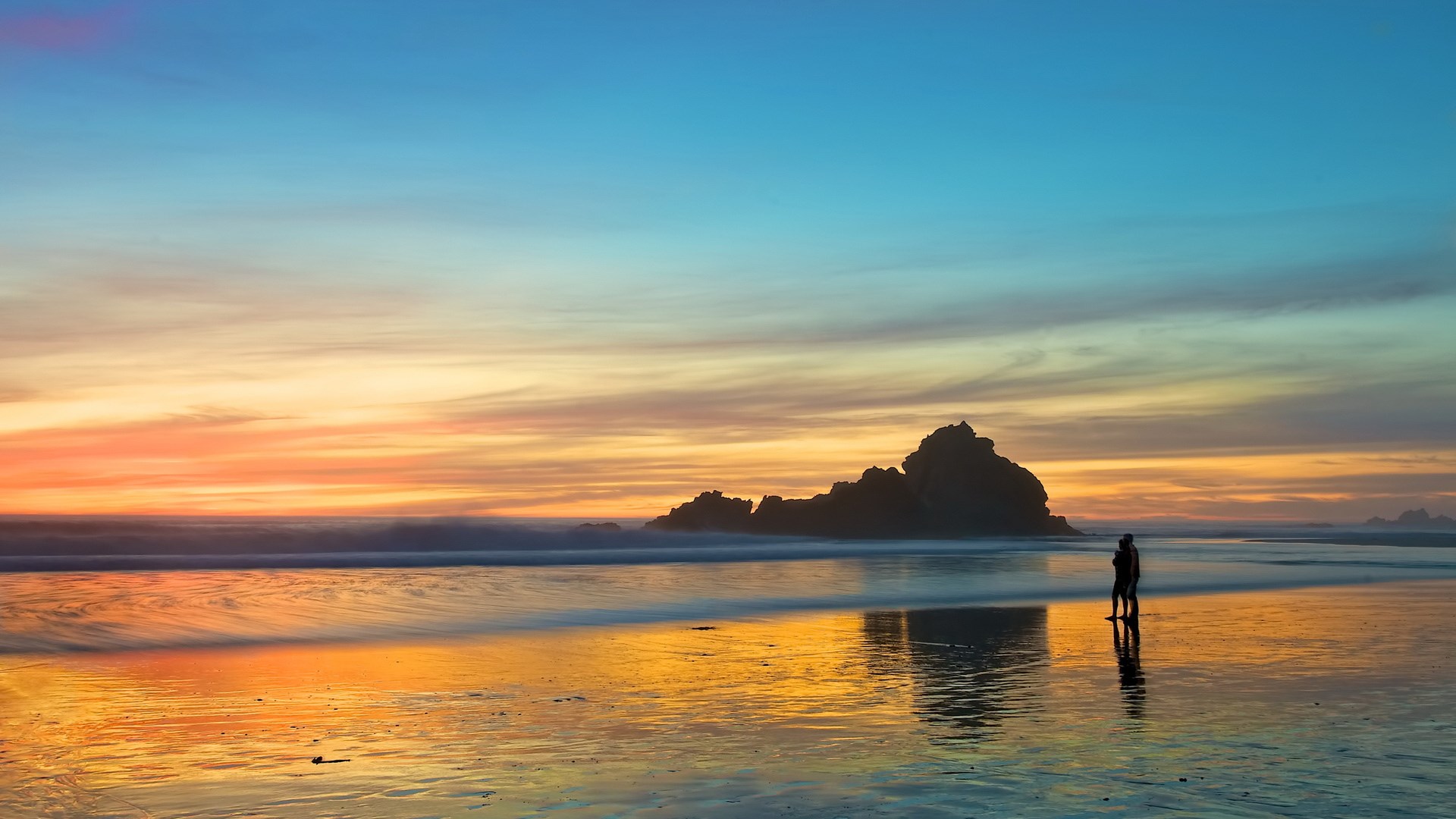 Couple on a beach at sunset HD Wallpaper