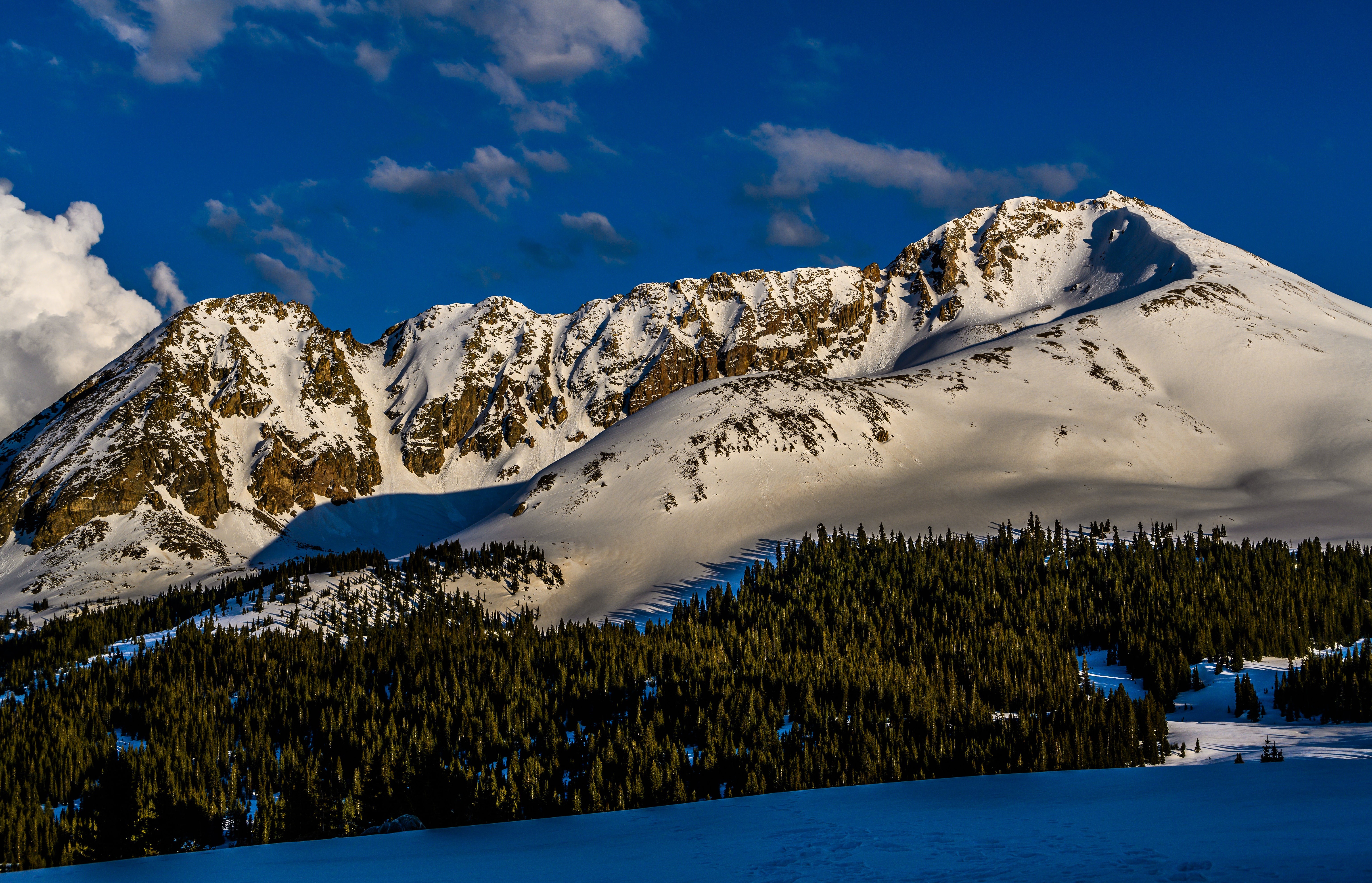 Snowy mountains under a blue sky with clouds HD Wallpaper