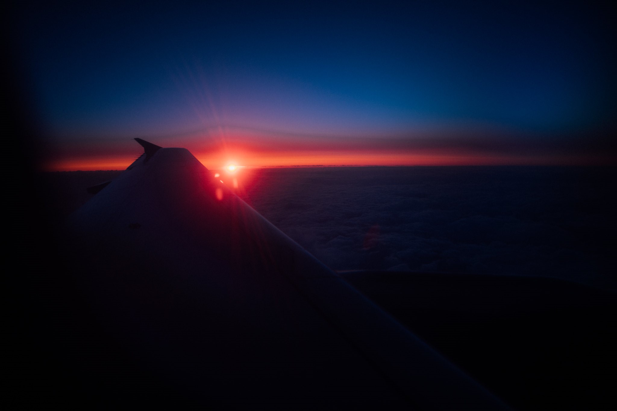 Airplane wing at sunset over clouds HD Wallpaper