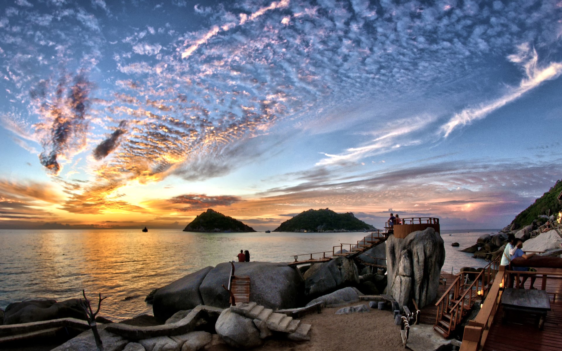 Sunset over islands with a wooden walkway and people HD Wallpaper