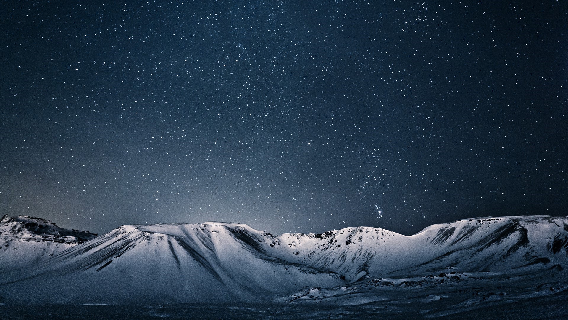 Snowy mountains under a starry night sky in Iceland HD Wallpaper