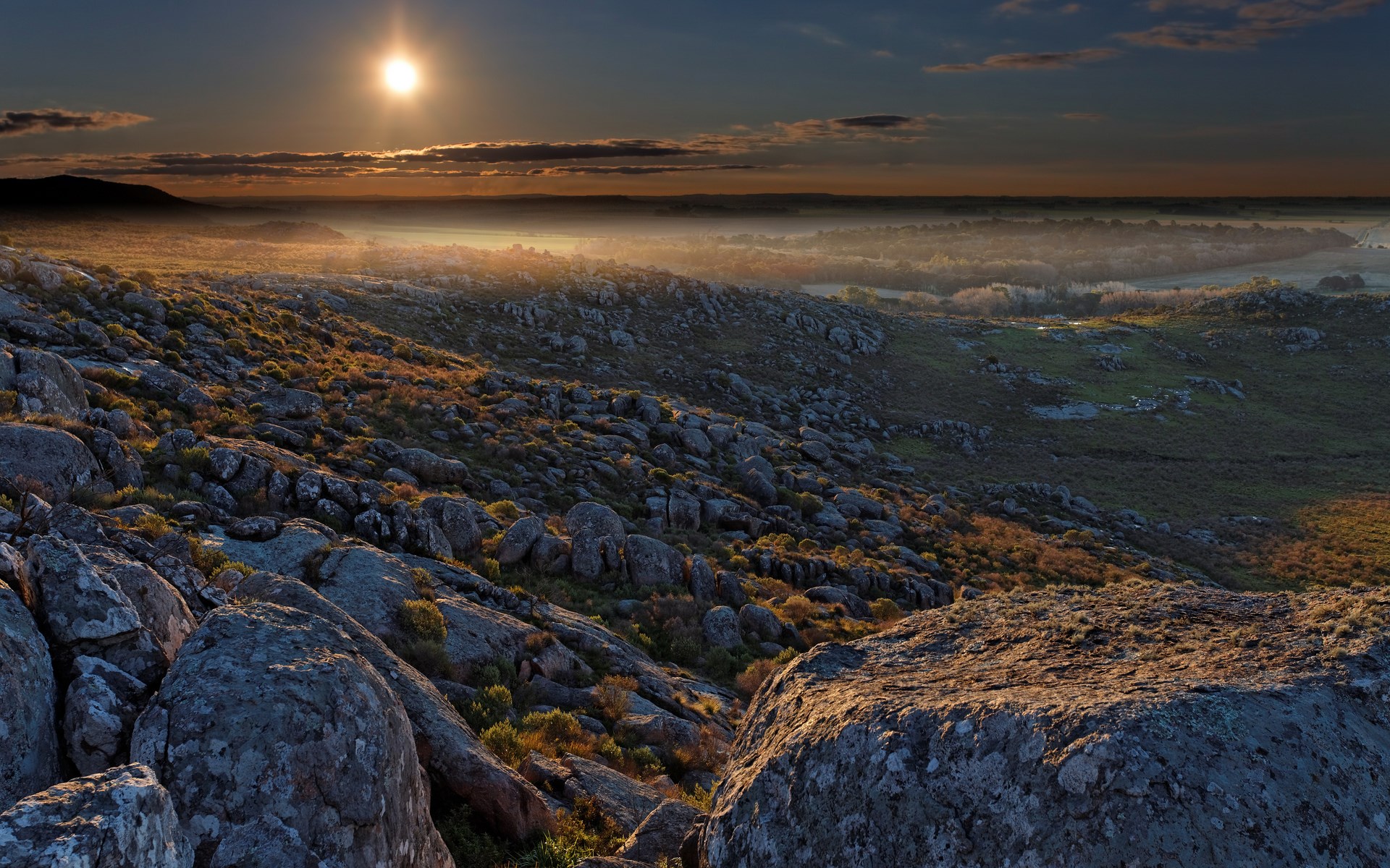 Sunrise over a rocky, misty landscape HD Wallpaper