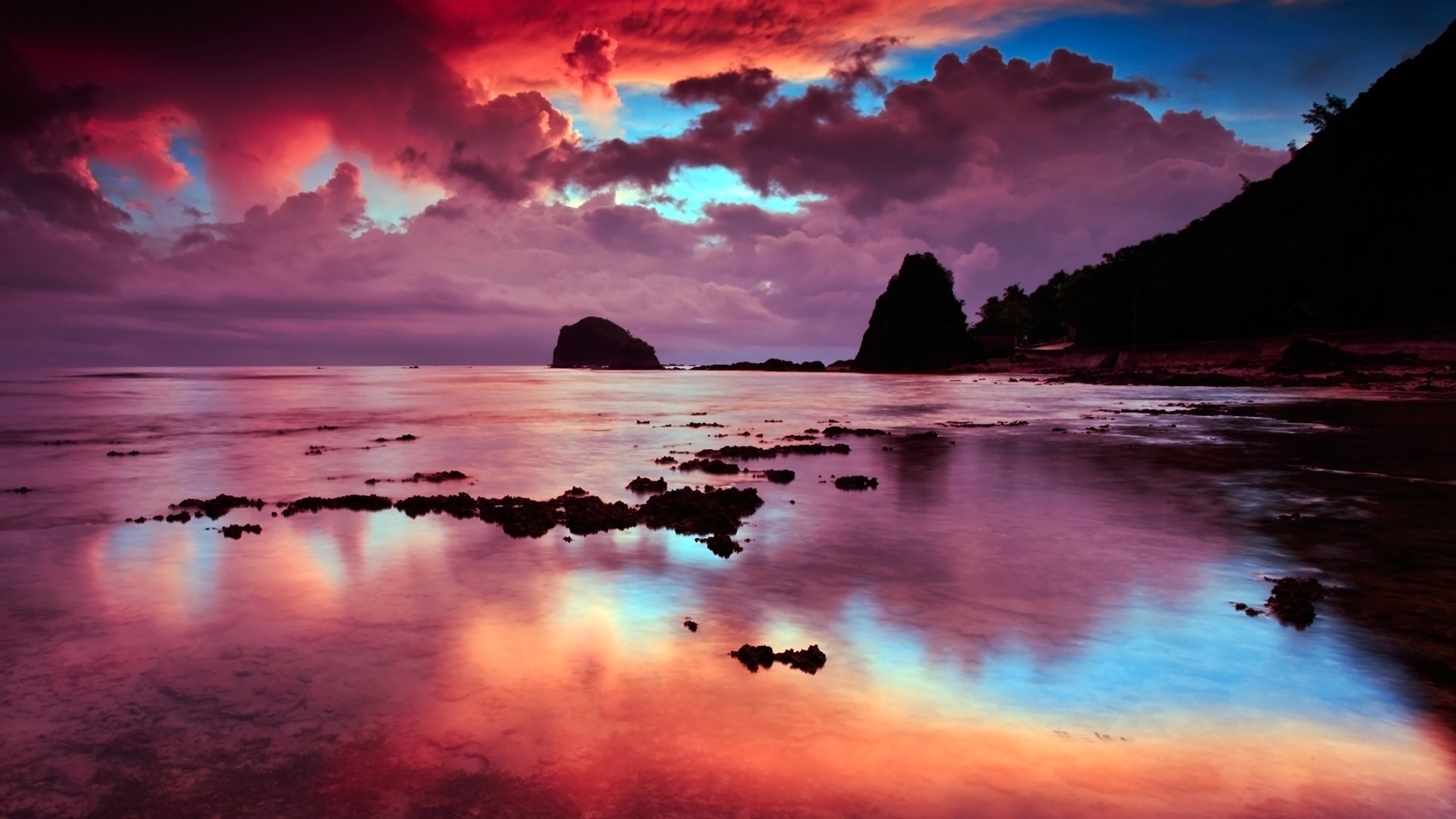 Sunset over a rocky beach with dramatic clouds HD Wallpaper
