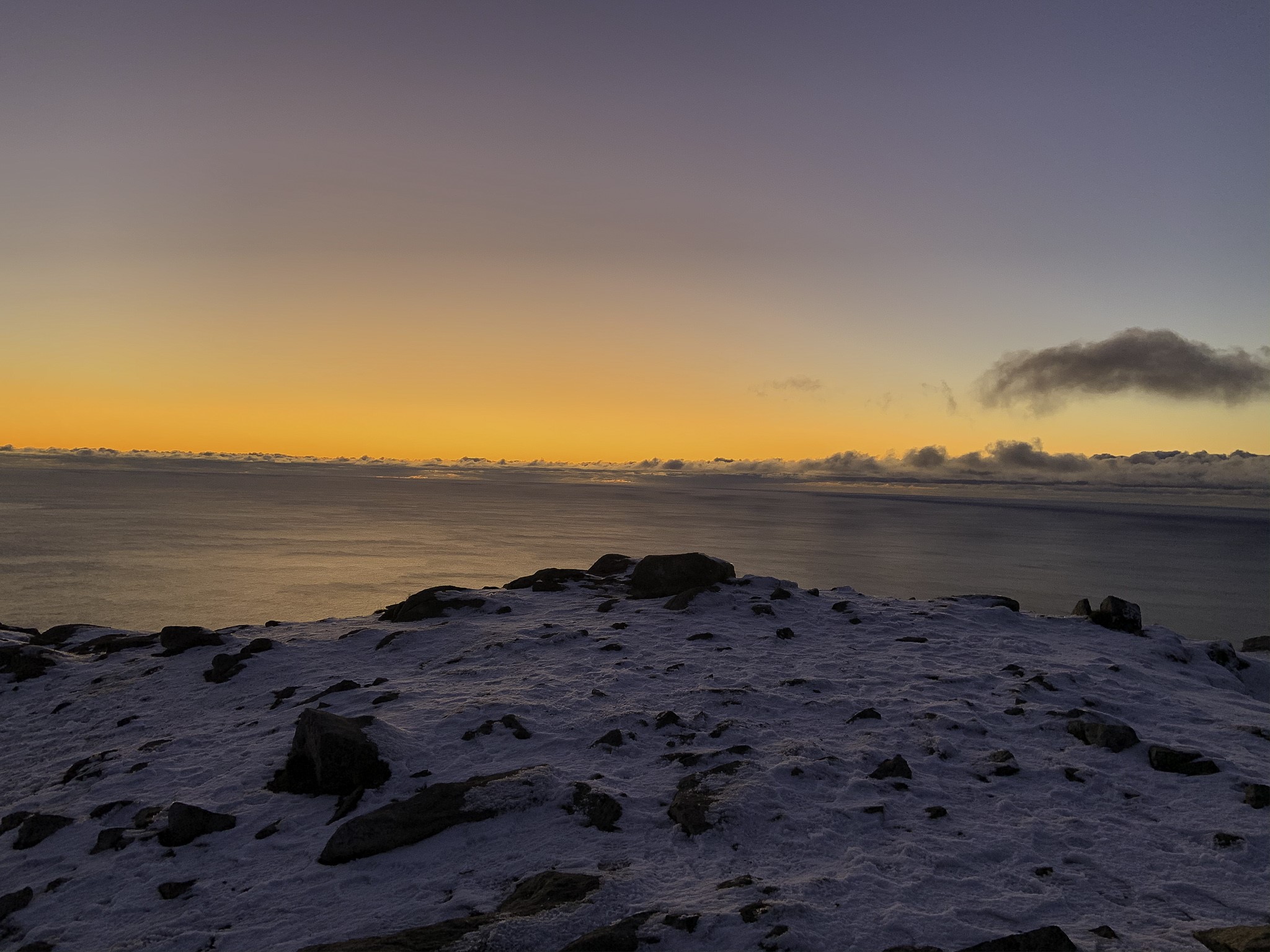 Snowy mountain peak overlooking the ocean at sunset HD Wallpaper