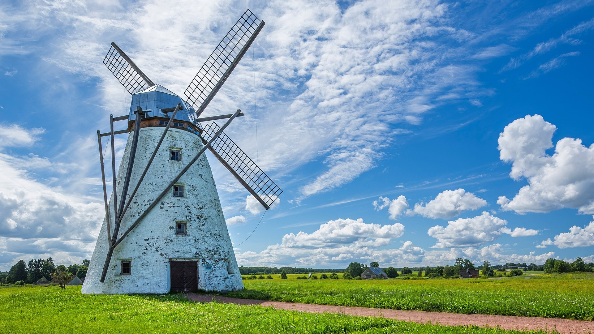 White windmill in a green field under a blue sky with clouds HD Wallpaper