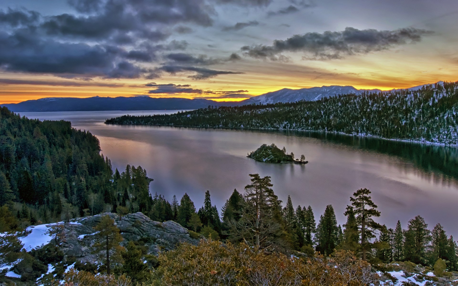 Lake Tahoe at sunset with snow-covered mountains and trees HD Wallpaper