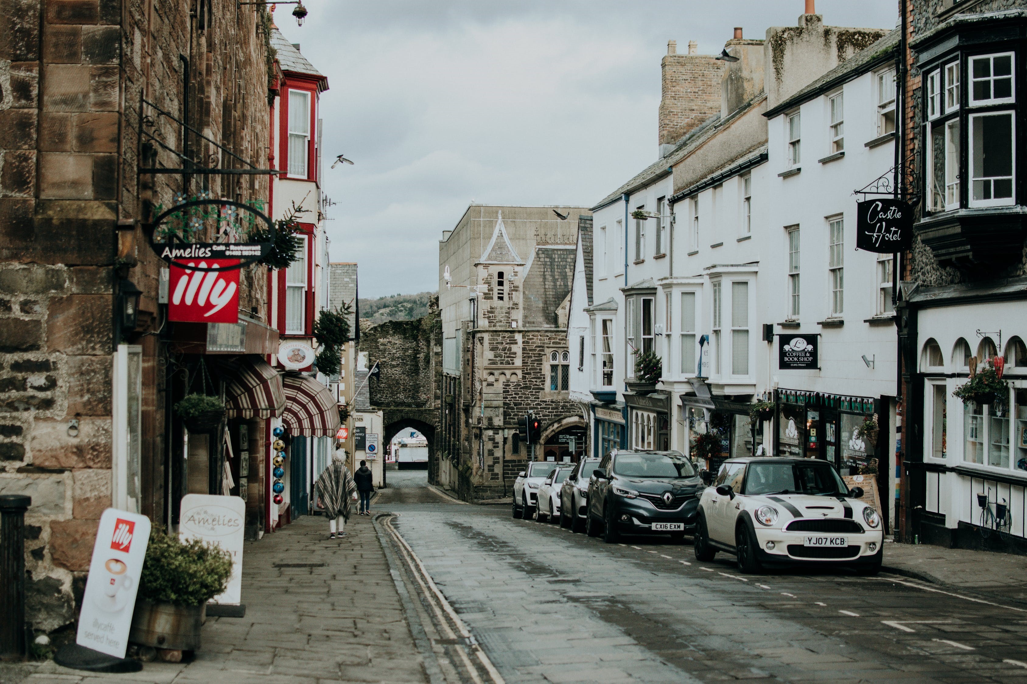 Street scene with shops and cars in a UK town HD Wallpaper