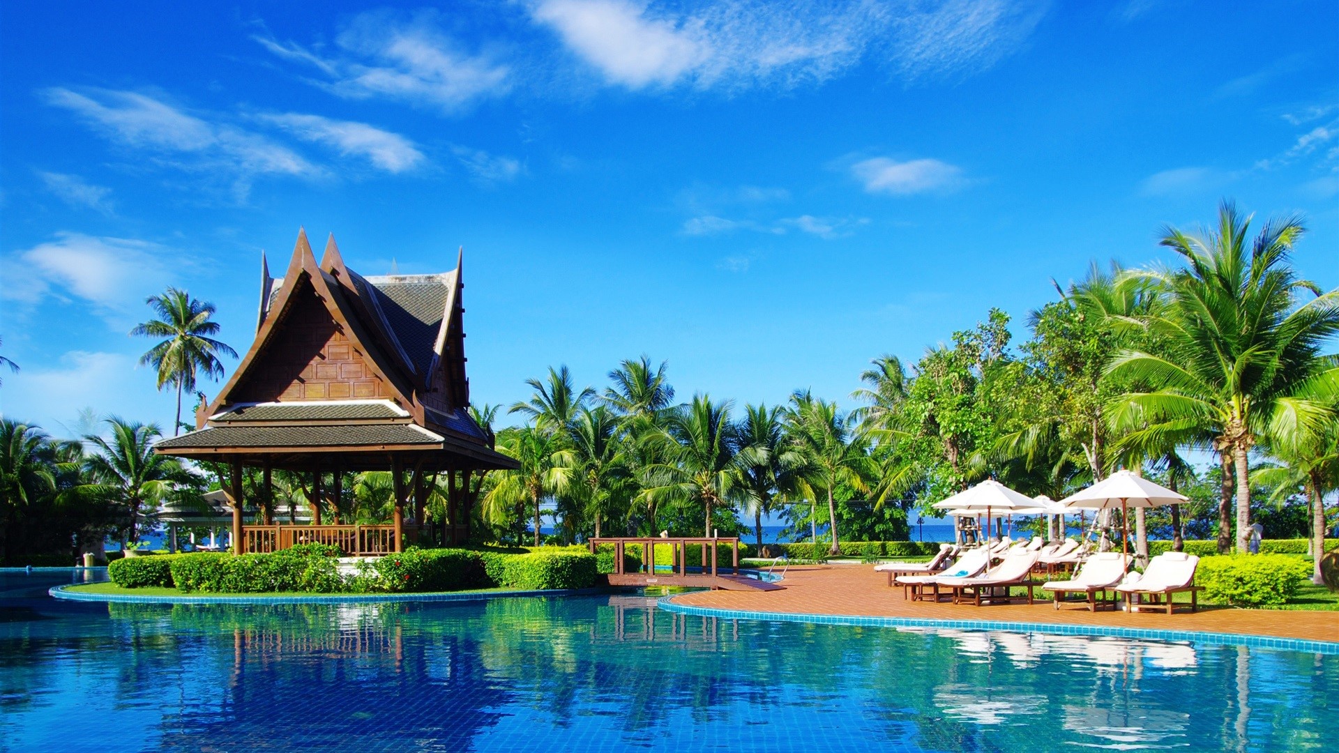 Tropical resort with swimming pool and traditional building HD Wallpaper