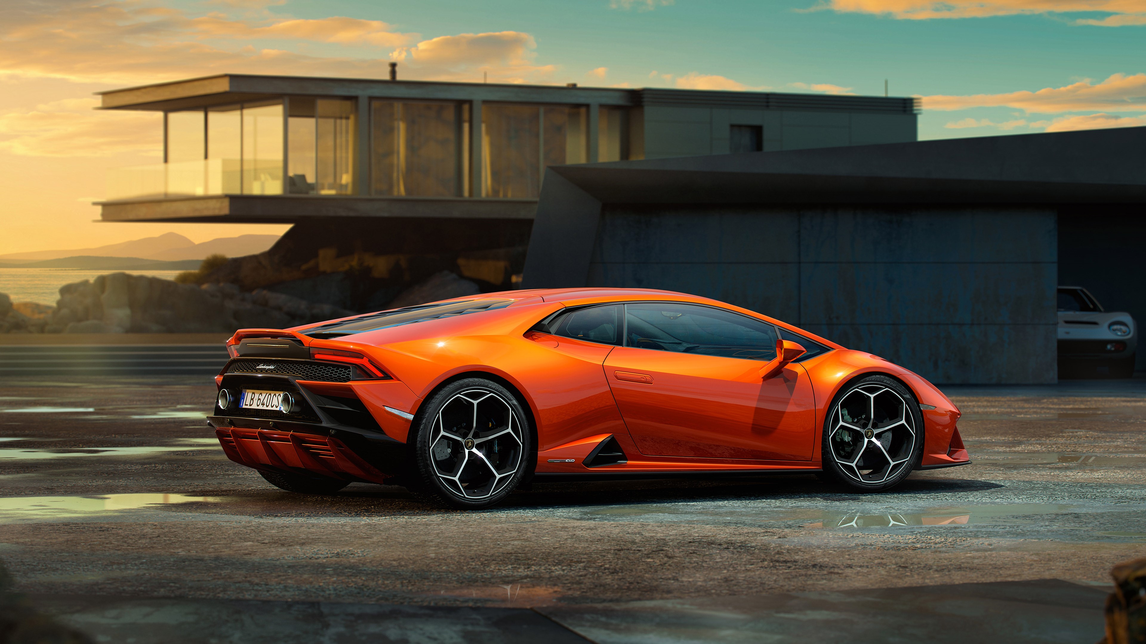 Orange Lamborghini Huracan parked near modern house at sunrise HD Wallpaper