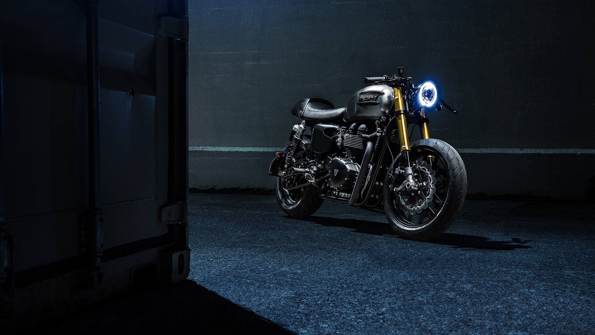Triumph motorcycle parked in dark alley HD Wallpaper
