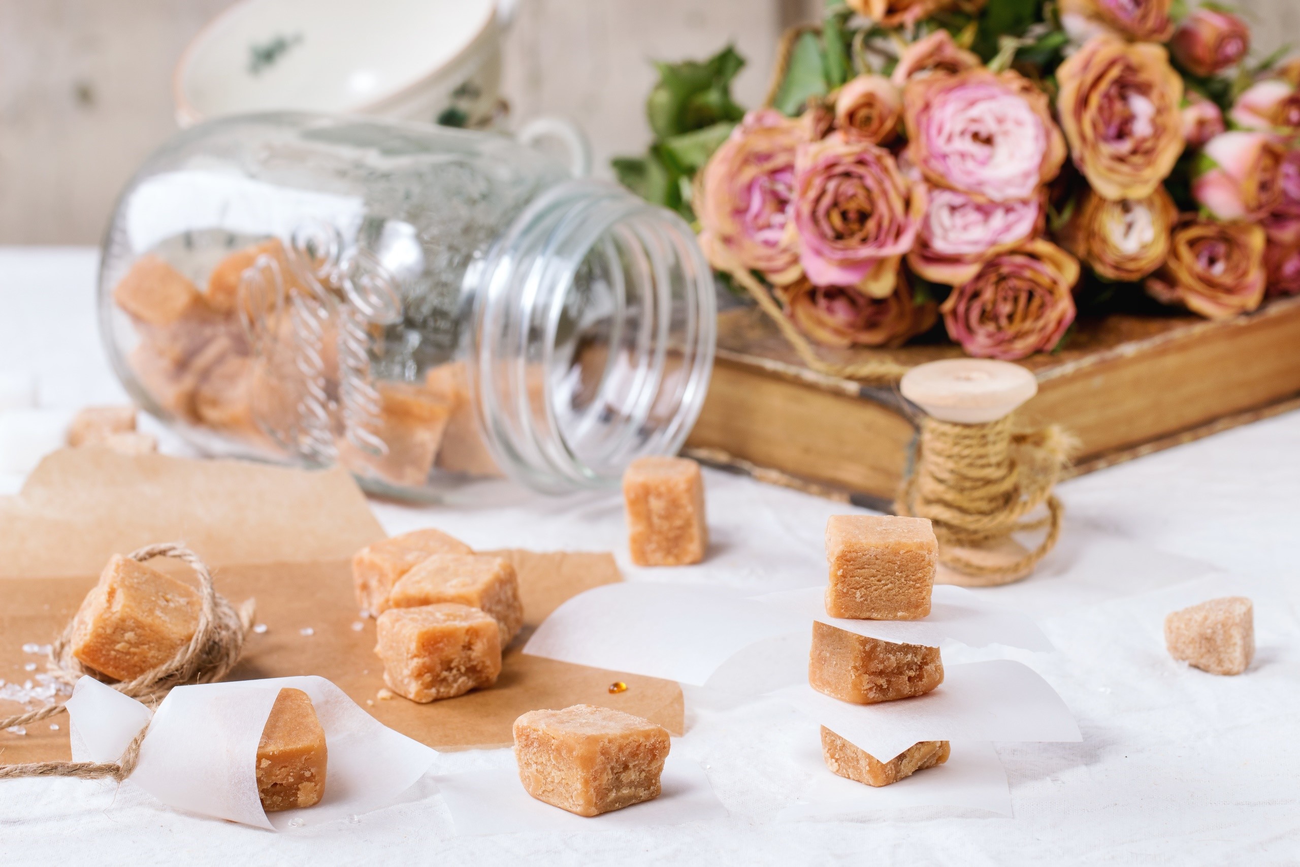 Fudge and dried roses on a table HD Wallpaper