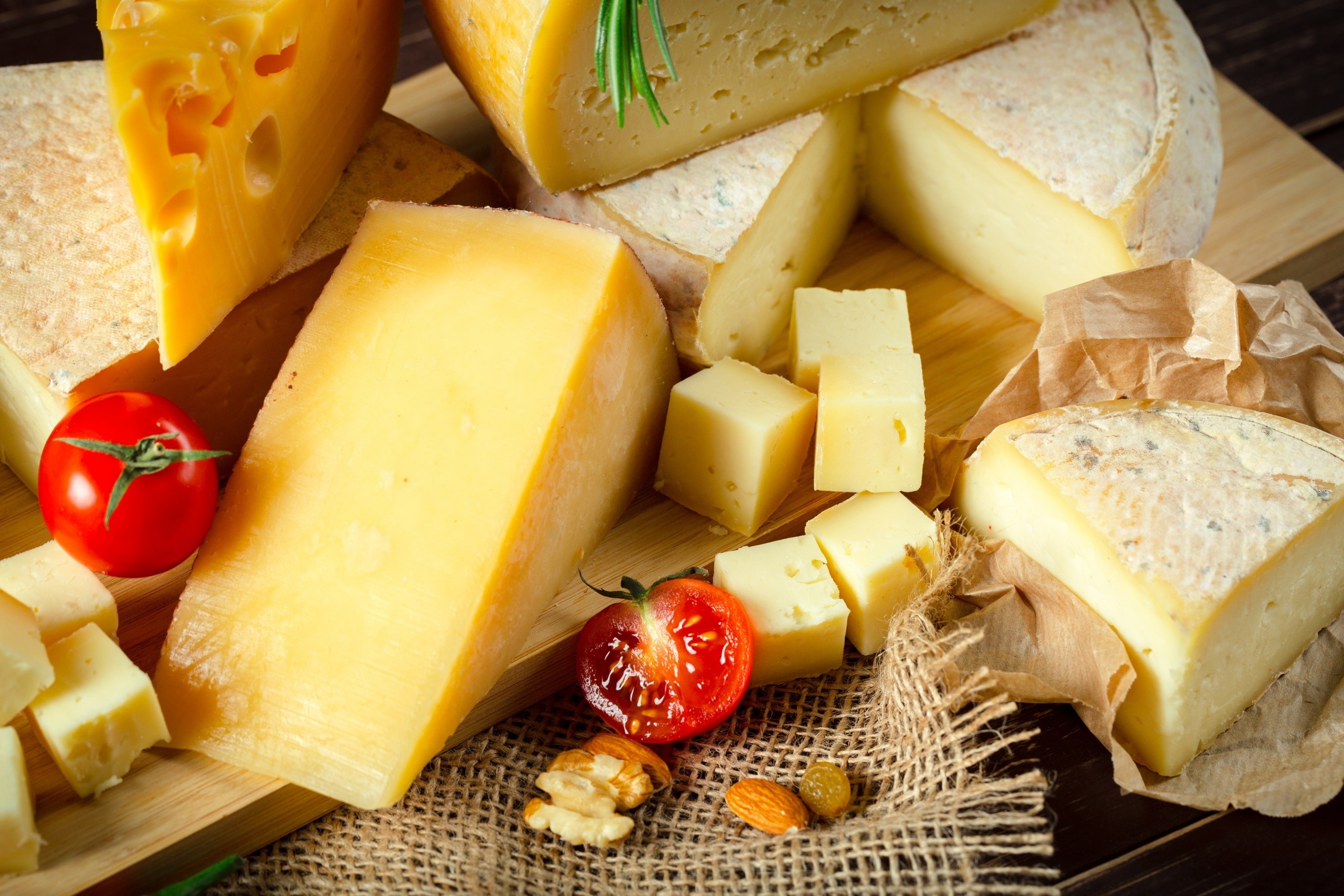 Assortment of cheeses with tomatoes and nuts HD Wallpaper