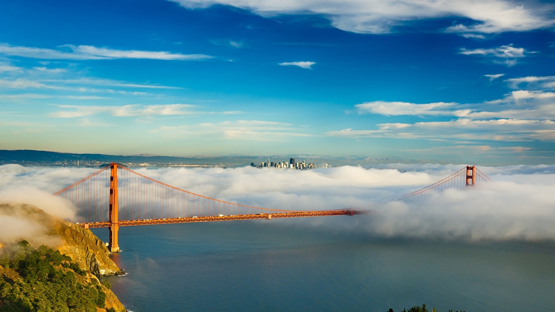 Golden Gate Bridge emerging from fog with San Francisco skyline HD Wallpaper
