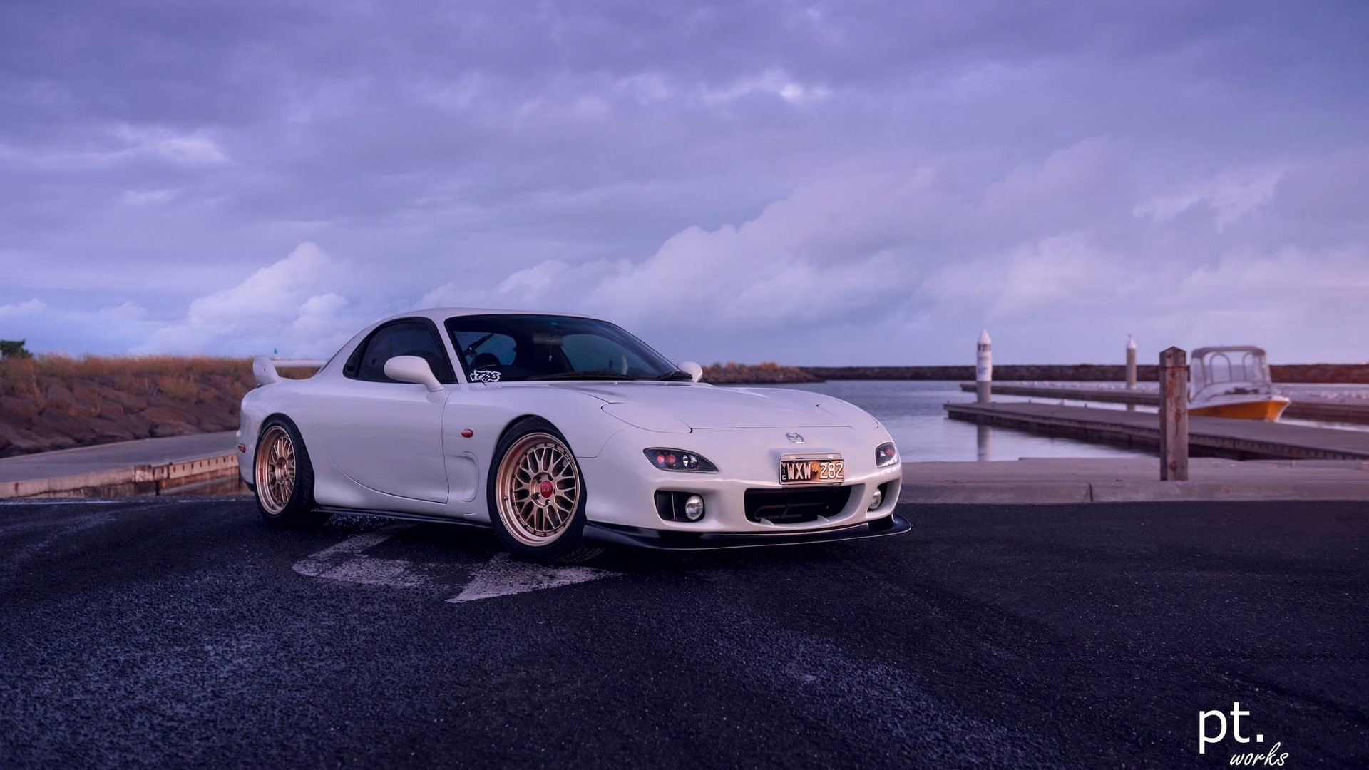 White Mazda RX-7 FD parked by a dock with boats HD Wallpaper