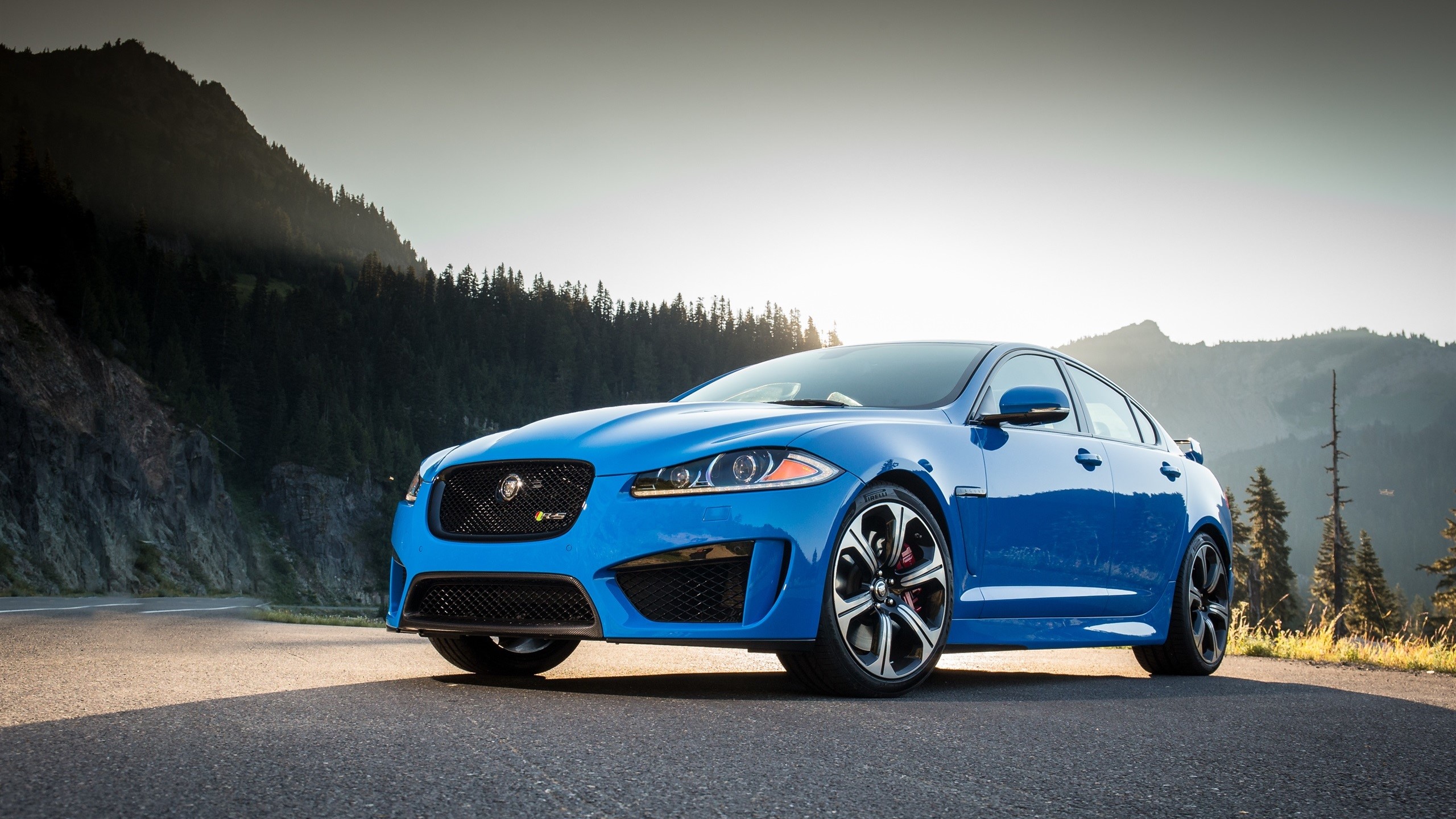 Blue Jaguar XF R parked on a mountain road HD Wallpaper