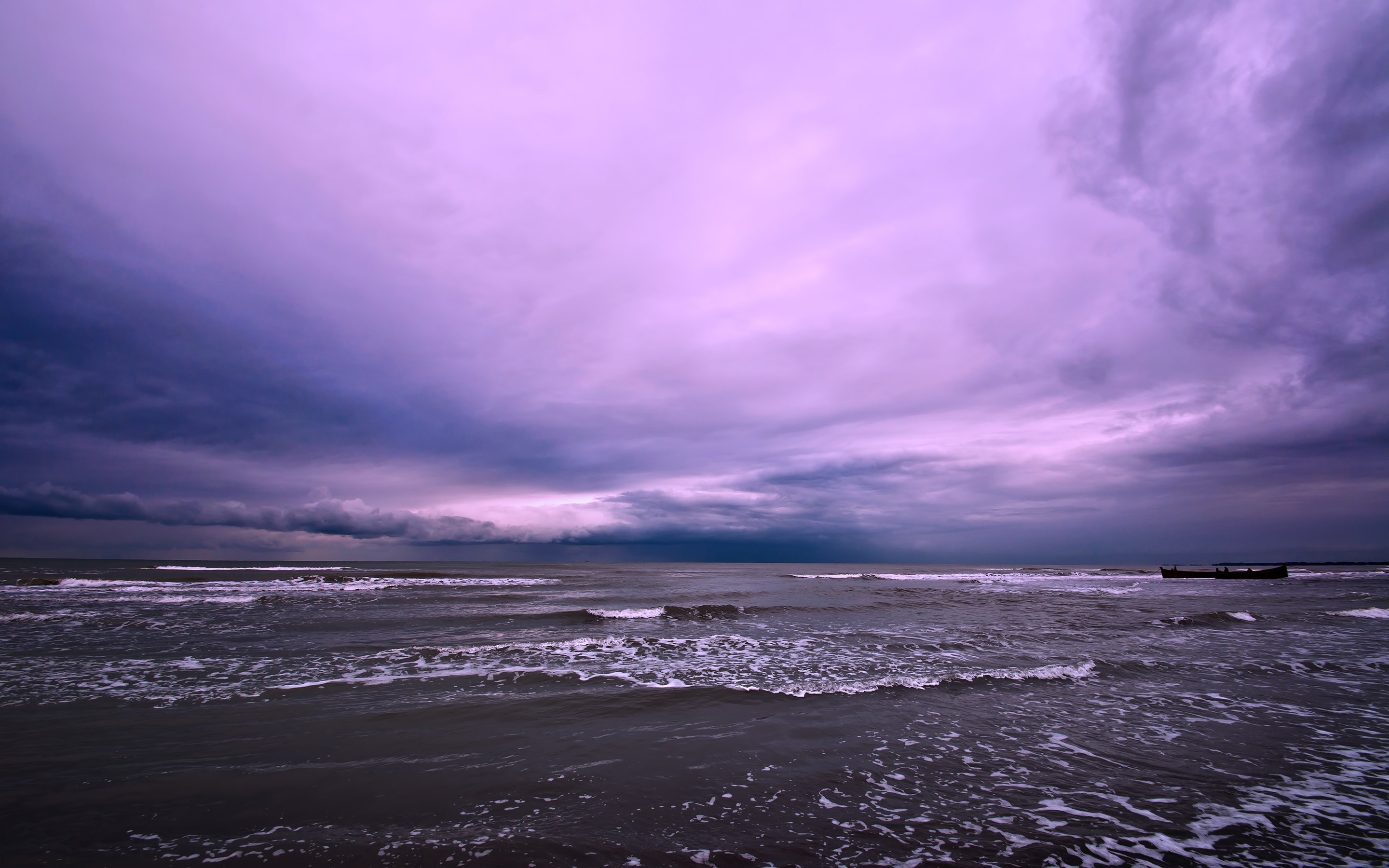 Stormy purple sky over a dark ocean with waves and a distant boat HD Wallpaper