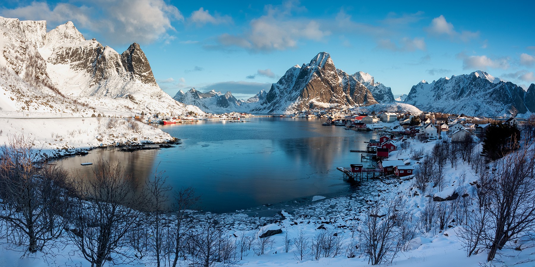 Snowy mountains and village by a lake in Reine, Norway HD Wallpaper