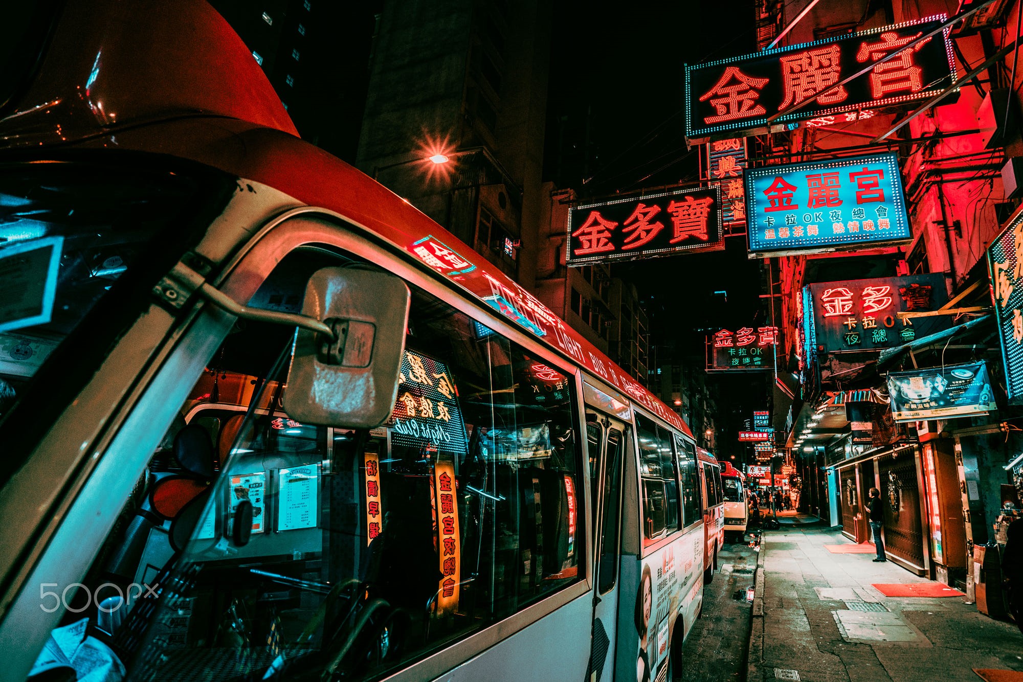Hong Kong street at night with neon signs and buses HD Wallpaper