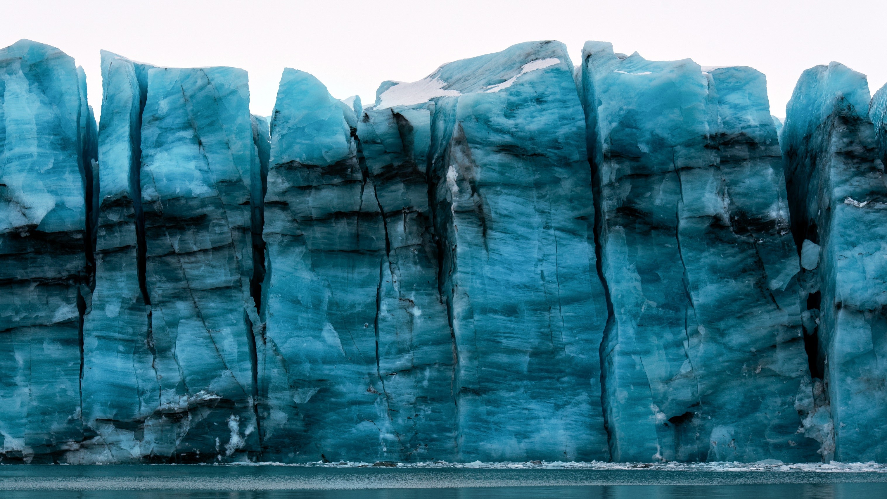 Massive blue glacier wall with dark streaks HD Wallpaper