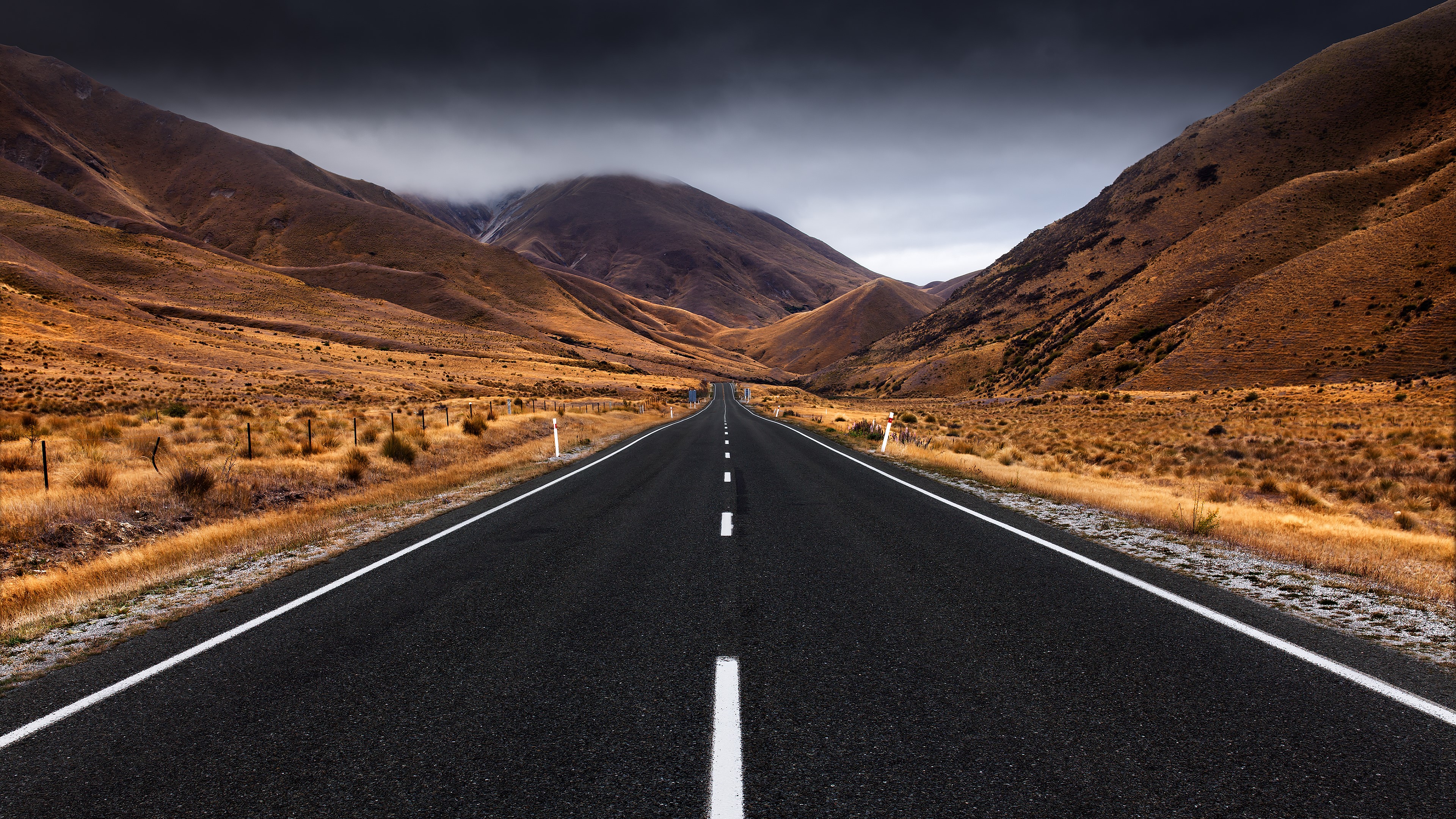 4K road through overcast hills landscape HD Wallpaper