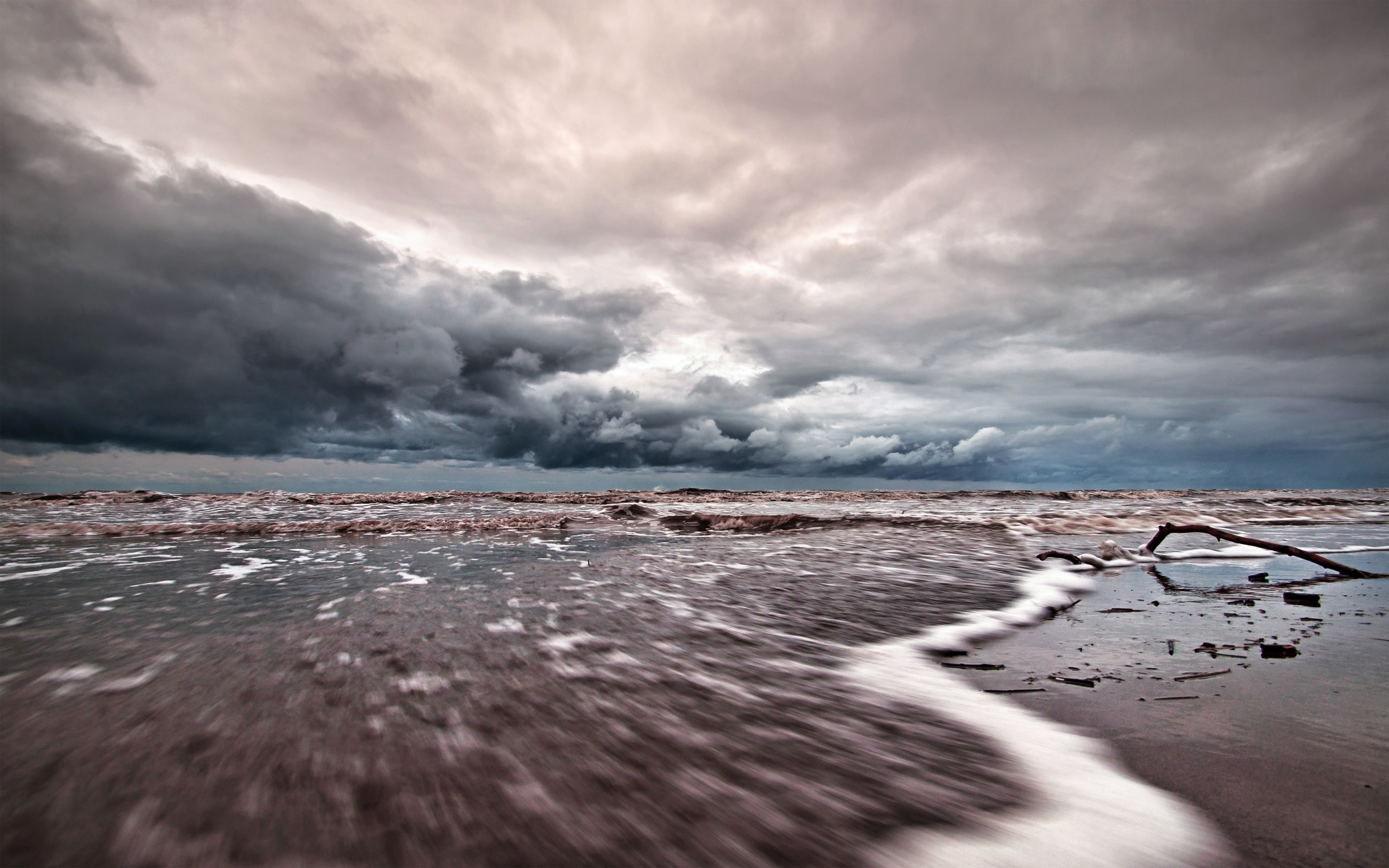 Stormy clouds over a dark, choppy sea and beach HD Wallpaper