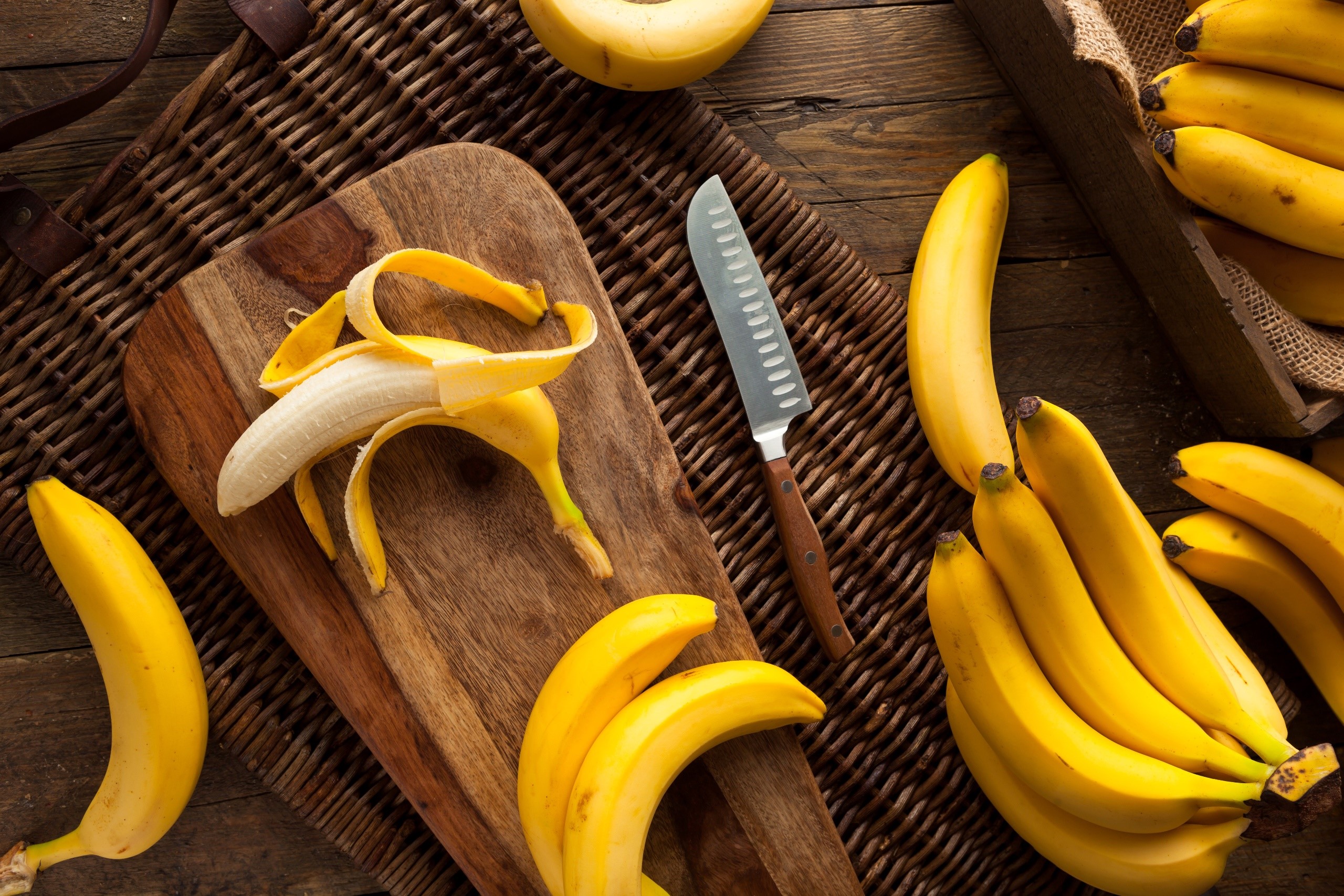 Bananas on a cutting board with a knife HD Wallpaper