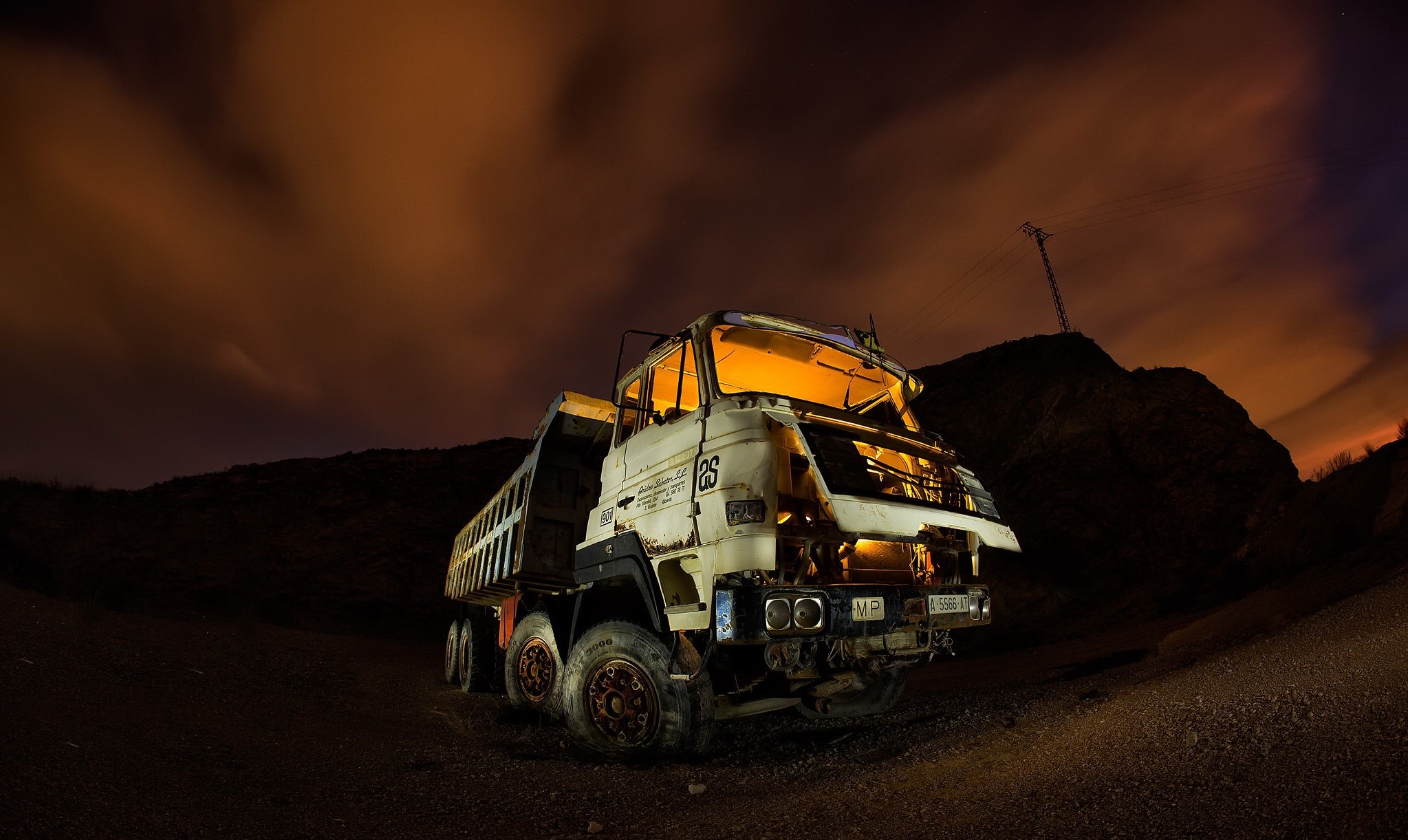 Old dump truck at night with orange clouds HD Wallpaper