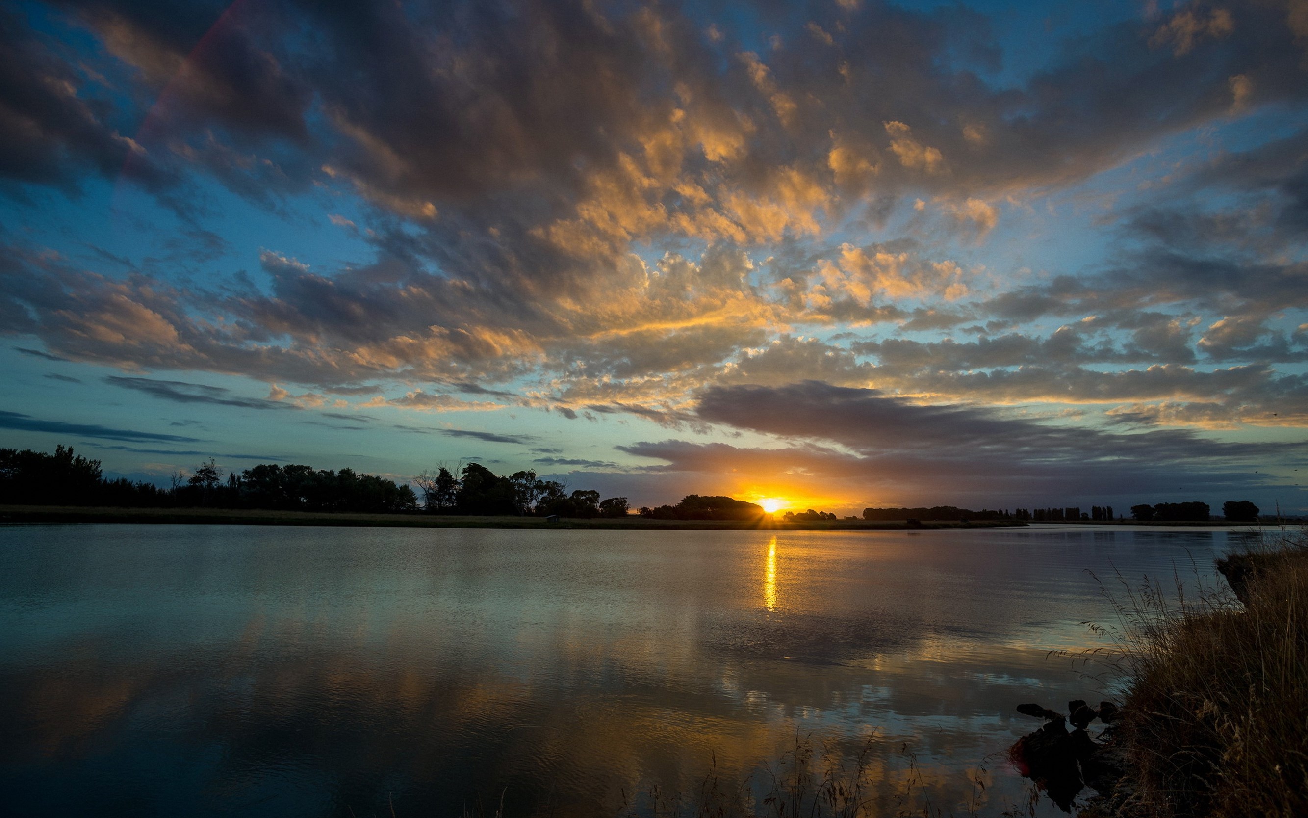 Sunset over a calm river with colorful clouds HD Wallpaper