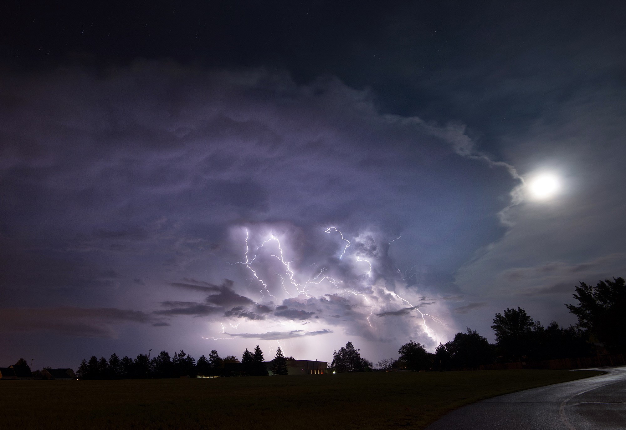 Lightning strikes during a night storm over a rural landscape HD Wallpaper
