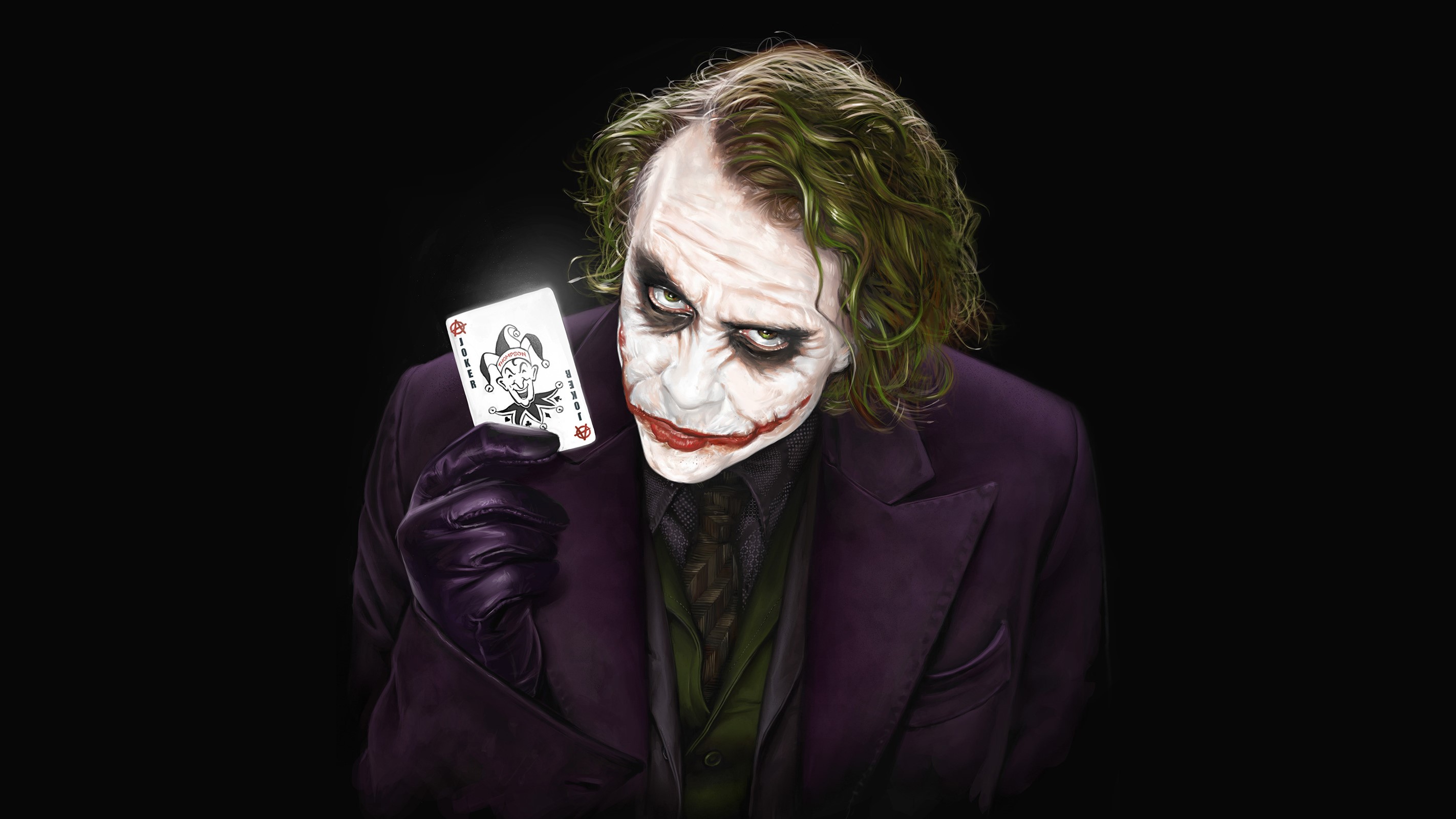 The Joker holding a playing card HD Wallpaper