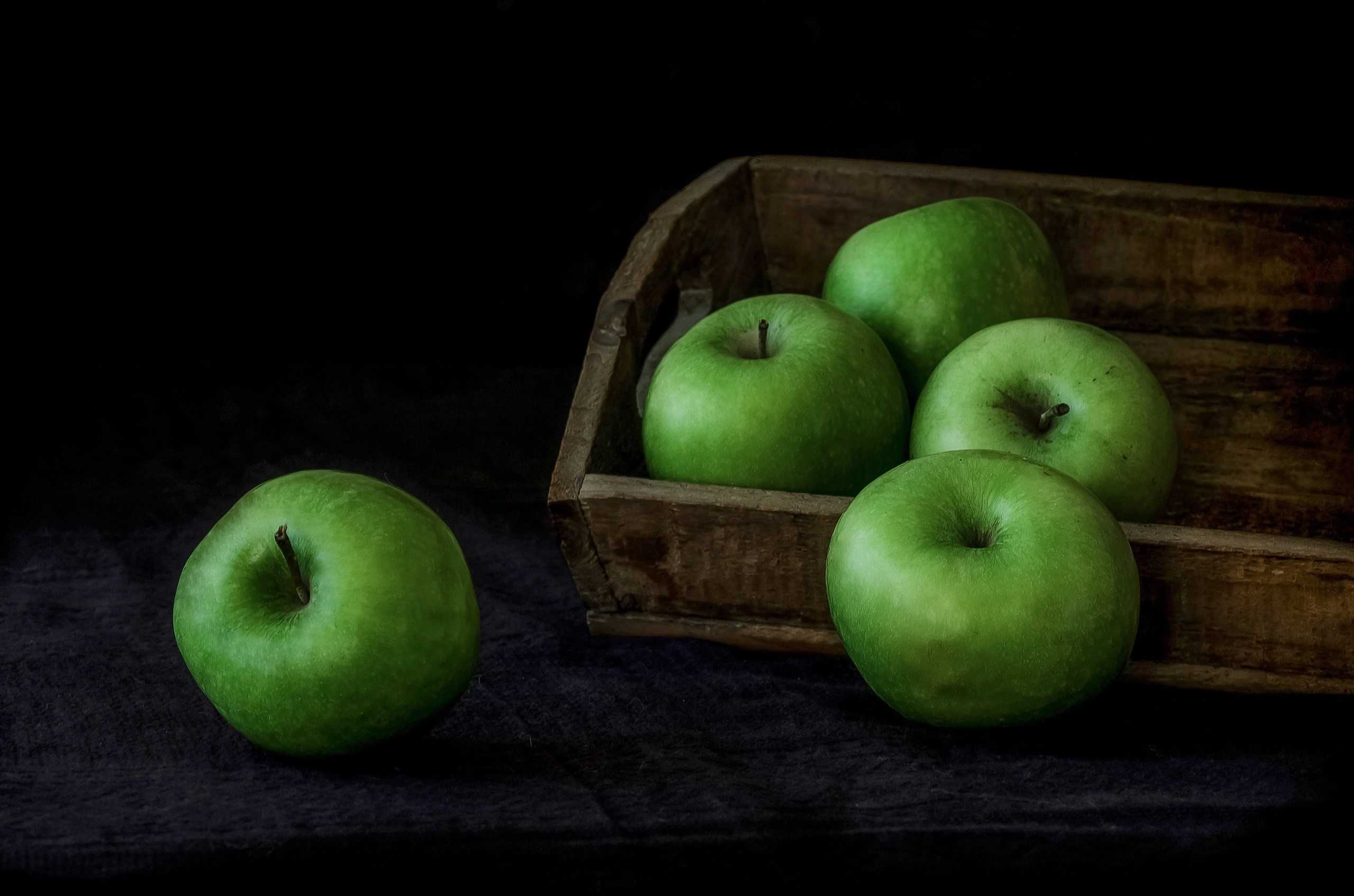 Green apples in a wooden crate and on a dark cloth HD Wallpaper