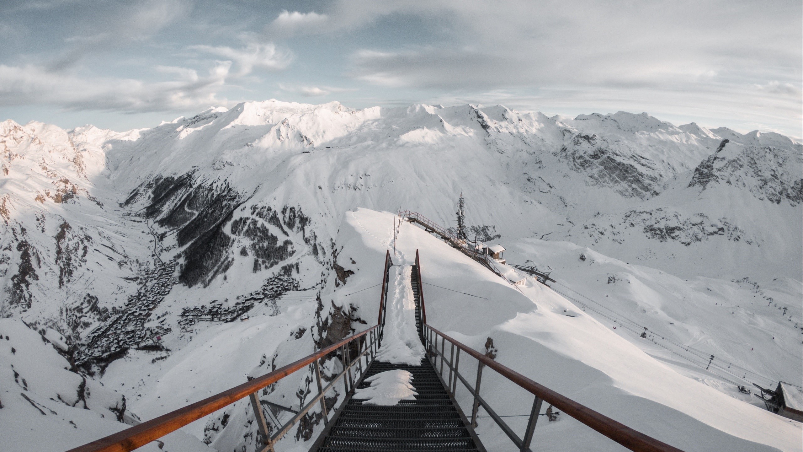 Snowy mountain range with a ski lift and village HD Wallpaper