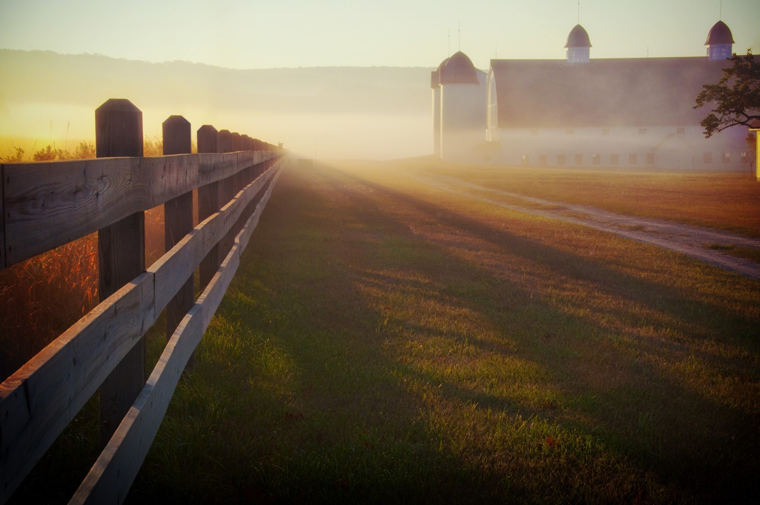 Farm buildings and fence at sunrise with fog HD Wallpaper