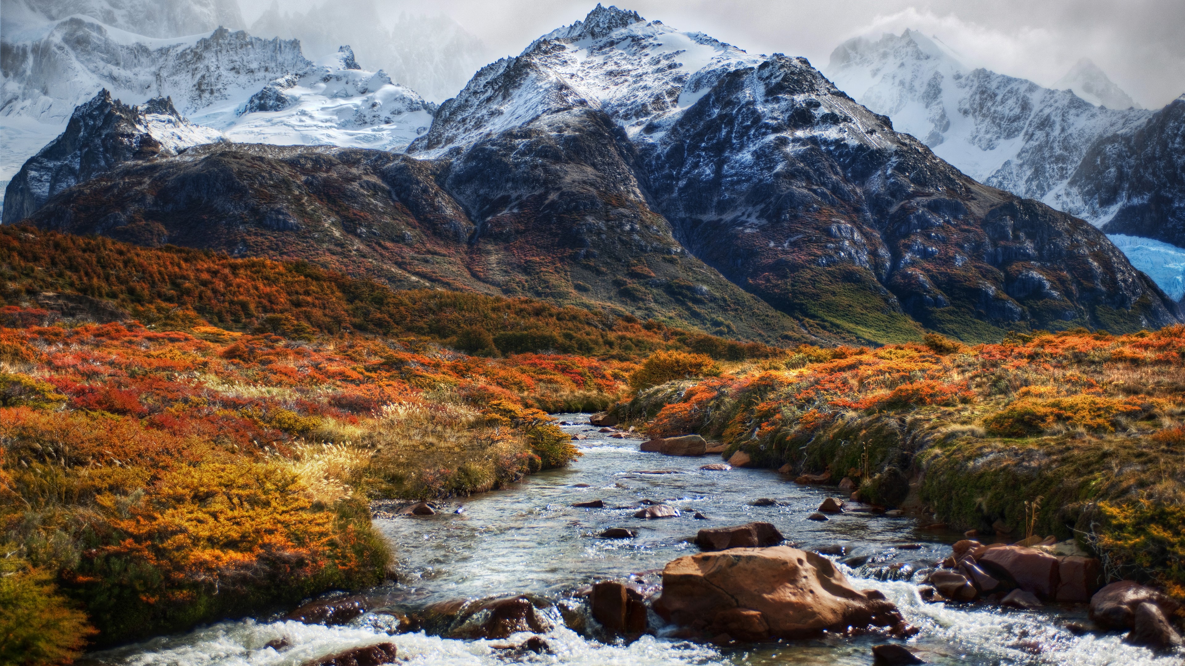 4K river flowing through autumn landscape with snowy mountains HD Wallpaper