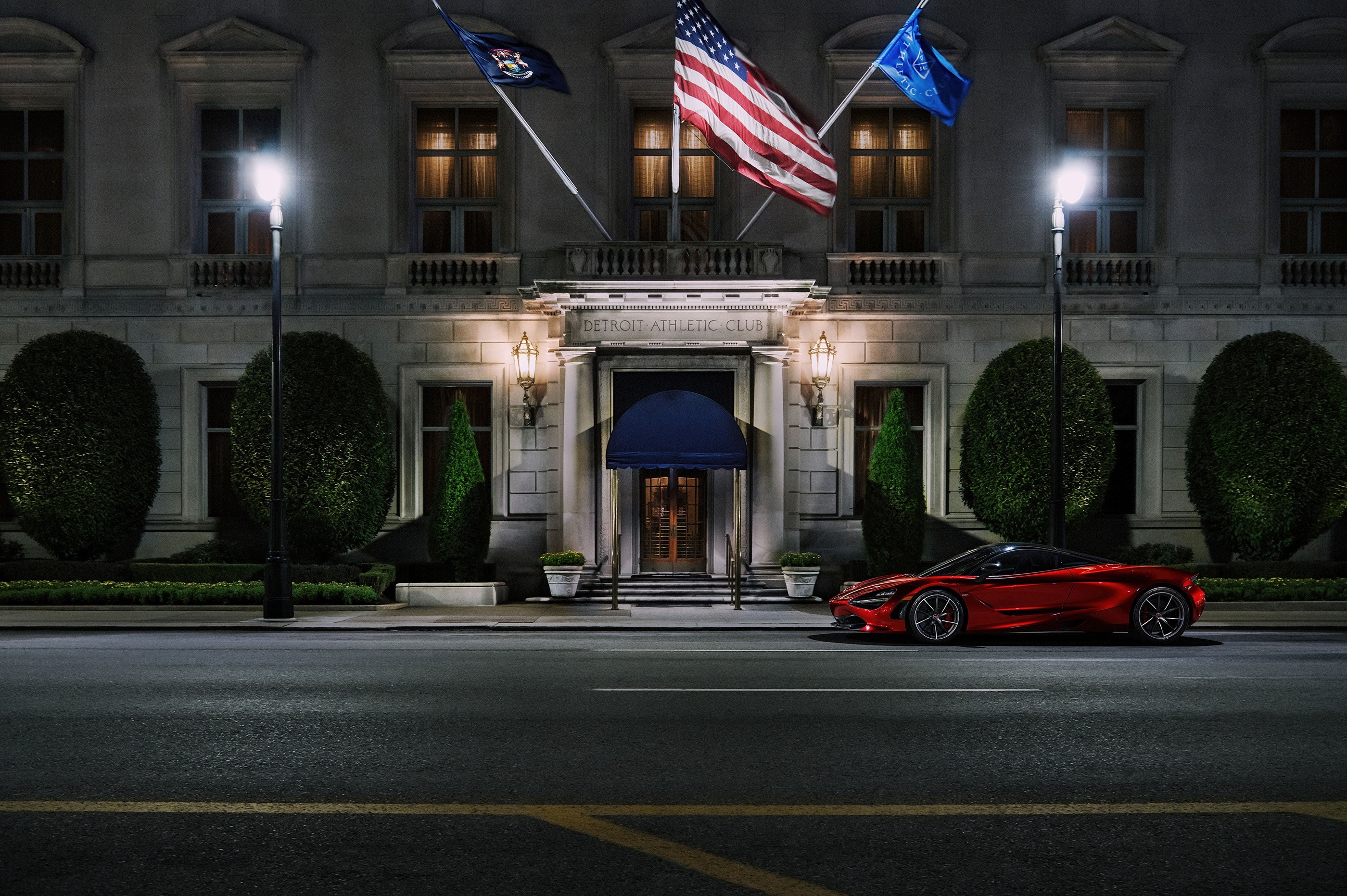 Red McLaren parked in front of Detroit Athletic Club at night HD Wallpaper