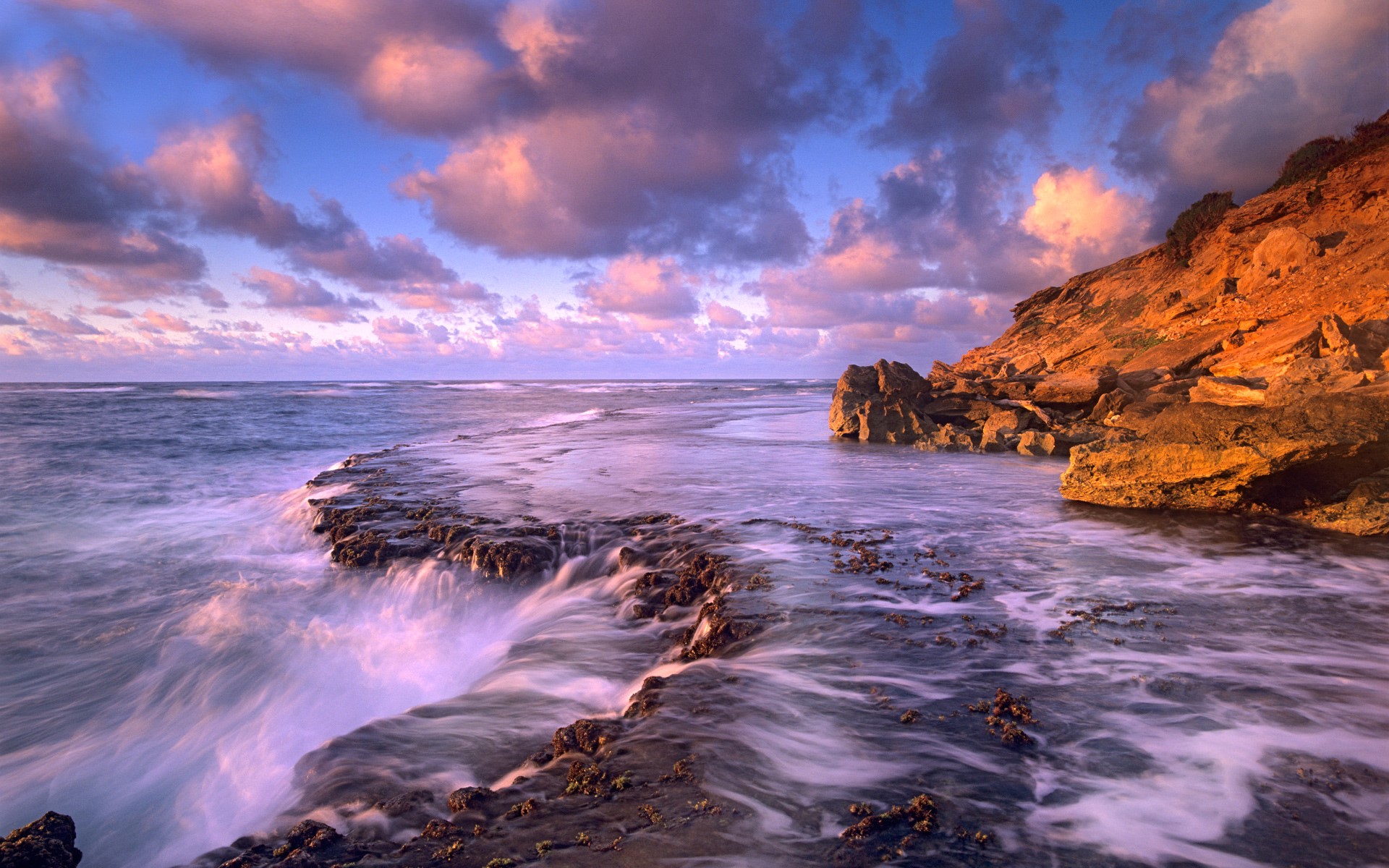 Ocean waves crashing on rocky coast at sunset HD Wallpaper