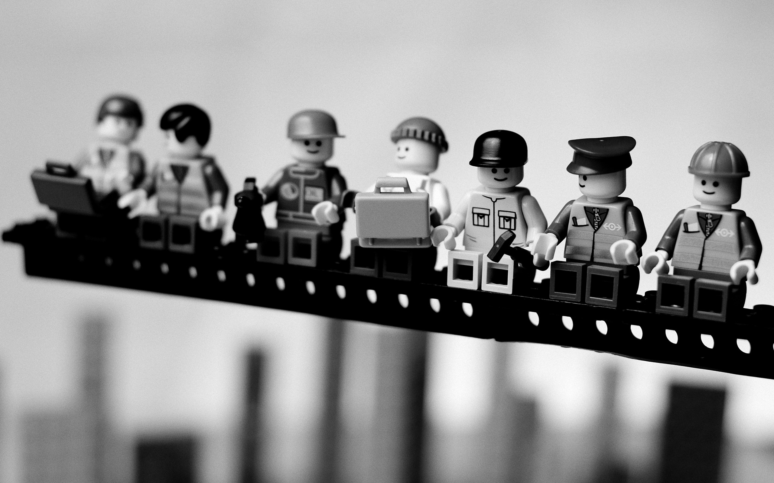 LEGO workers on a platform with blurred skyscrapers HD Wallpaper